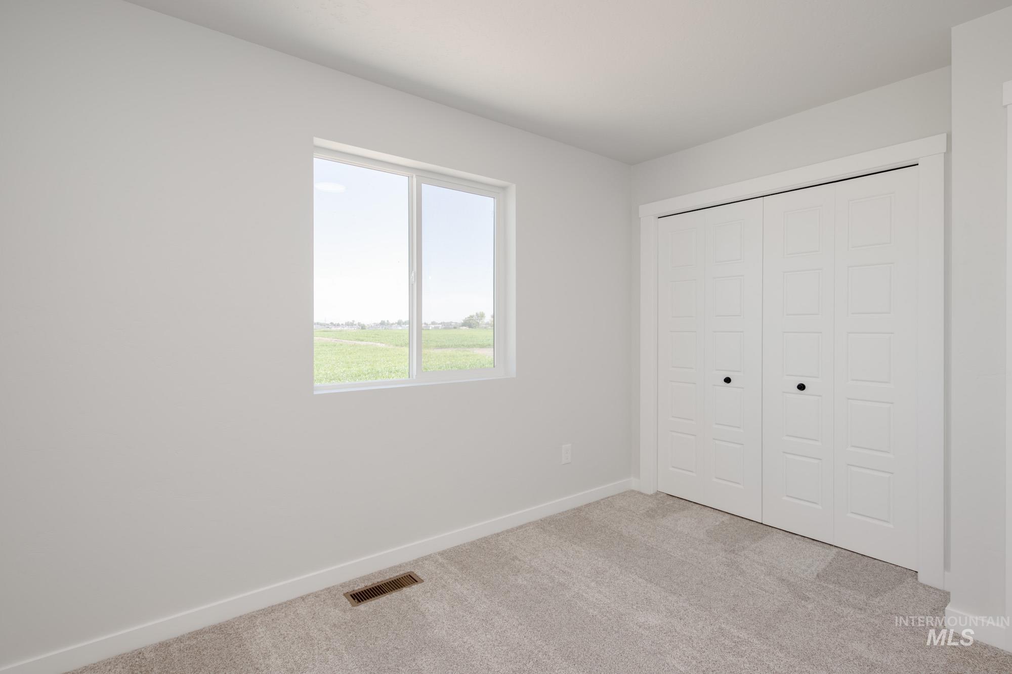 Unfurnished bedroom with light colored carpet and a closet