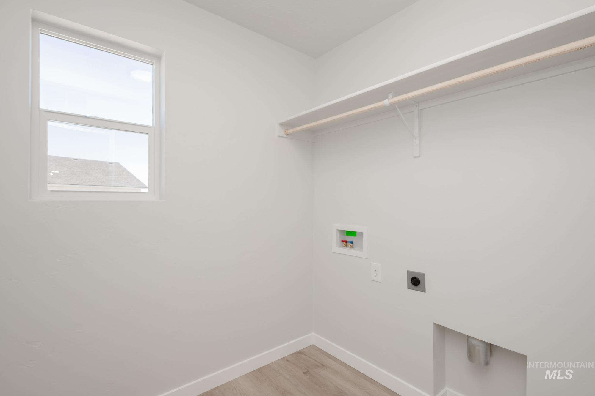 Laundry room with light wood finished floors, electric dryer hookup, and hookup for a washing machine