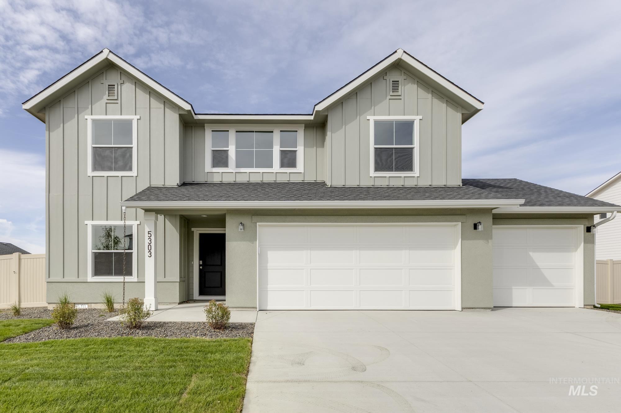 View of front of home with board and batten siding, roof with shingles, concrete driveway, and an attached garage