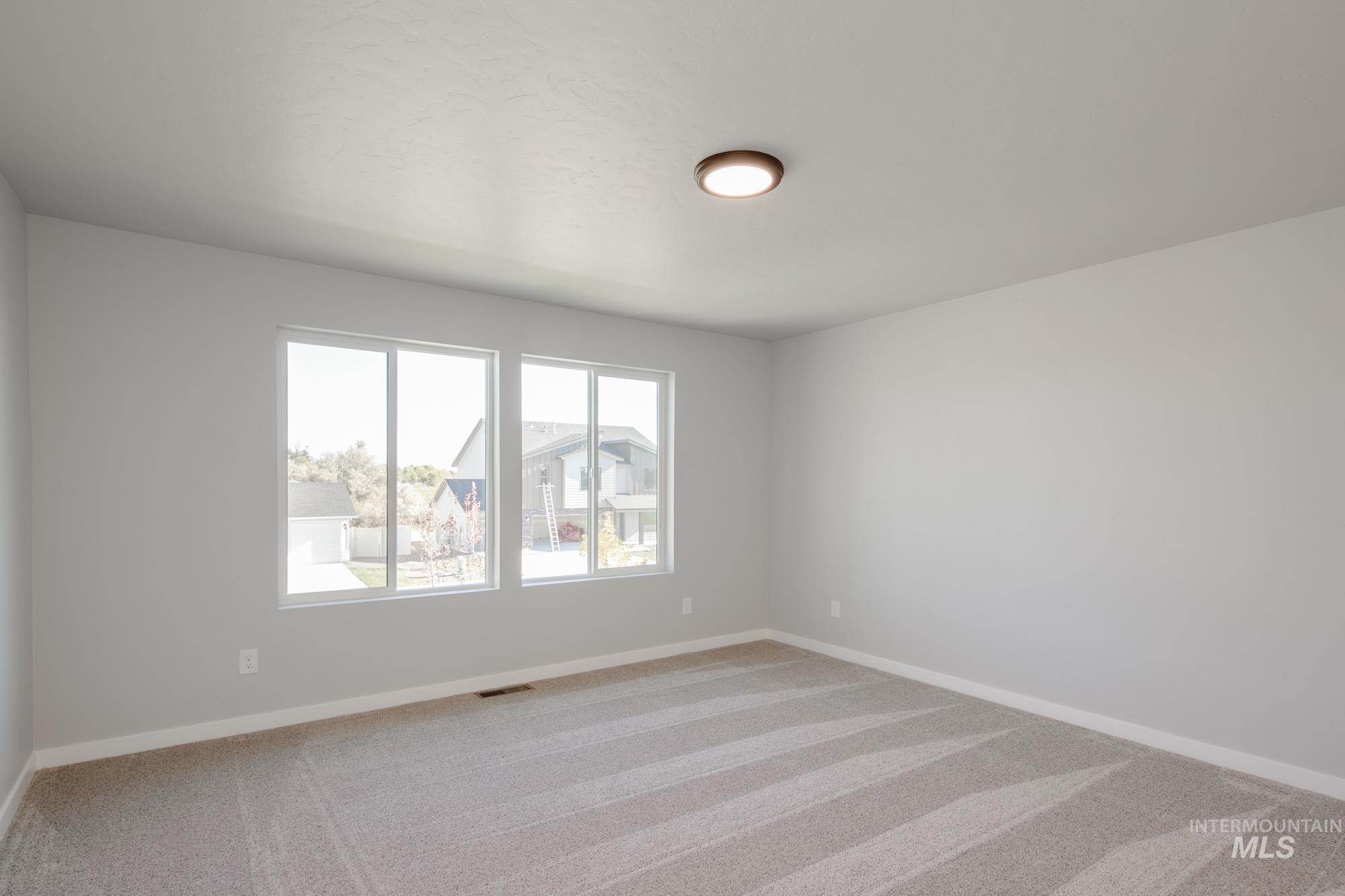 Empty room featuring light carpet and baseboards