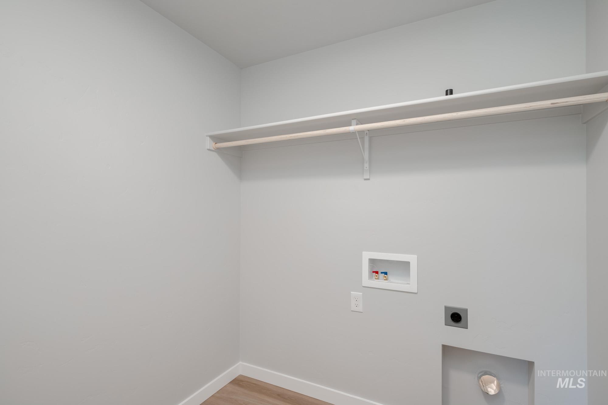 Washroom featuring washer hookup, light wood-type flooring, and electric dryer hookup