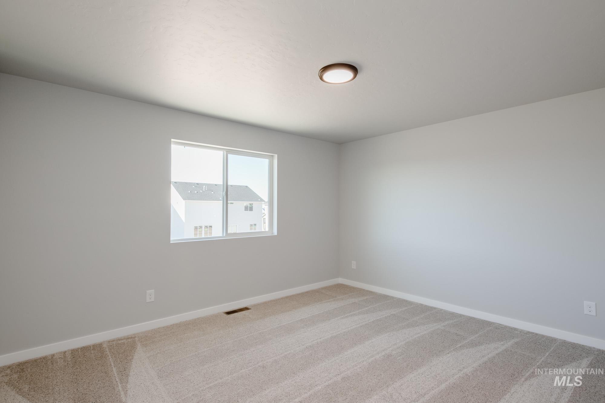 Empty room featuring baseboards and light colored carpet