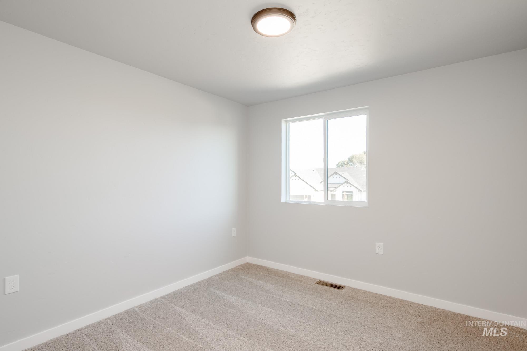 Spare room featuring baseboards and carpet floors