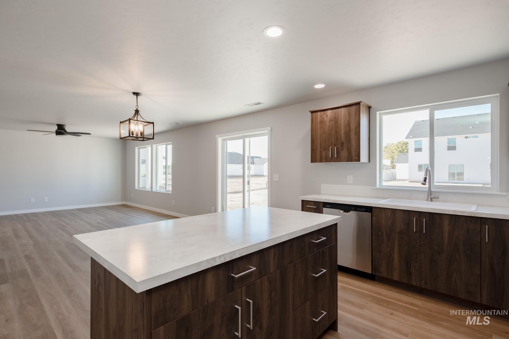 Kitchen with a kitchen island, dark brown cabinetry, light wood-style flooring, and recessed lighting
