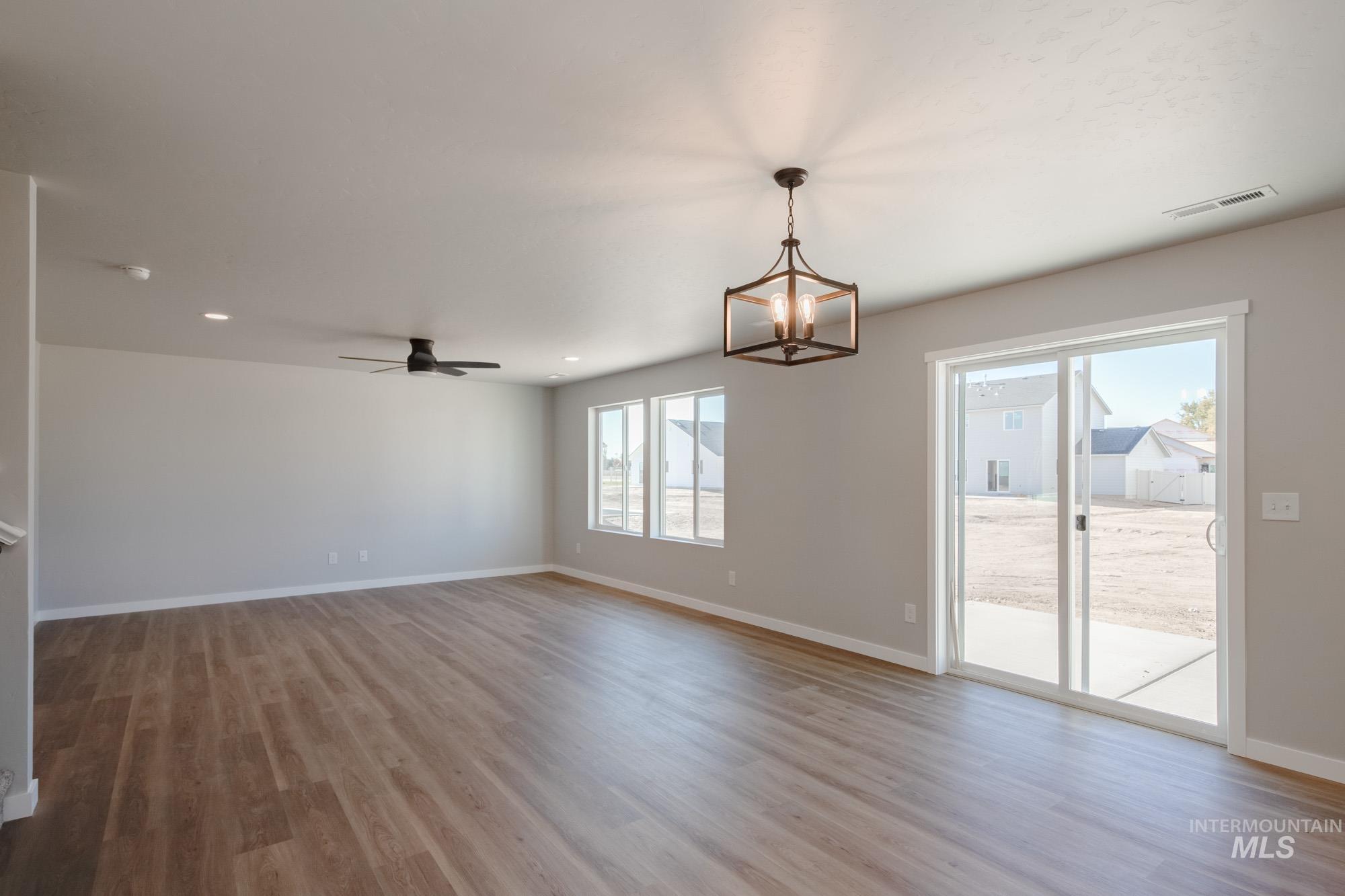 Unfurnished dining area with light wood-type flooring, a chandelier, ceiling fan, and recessed lighting