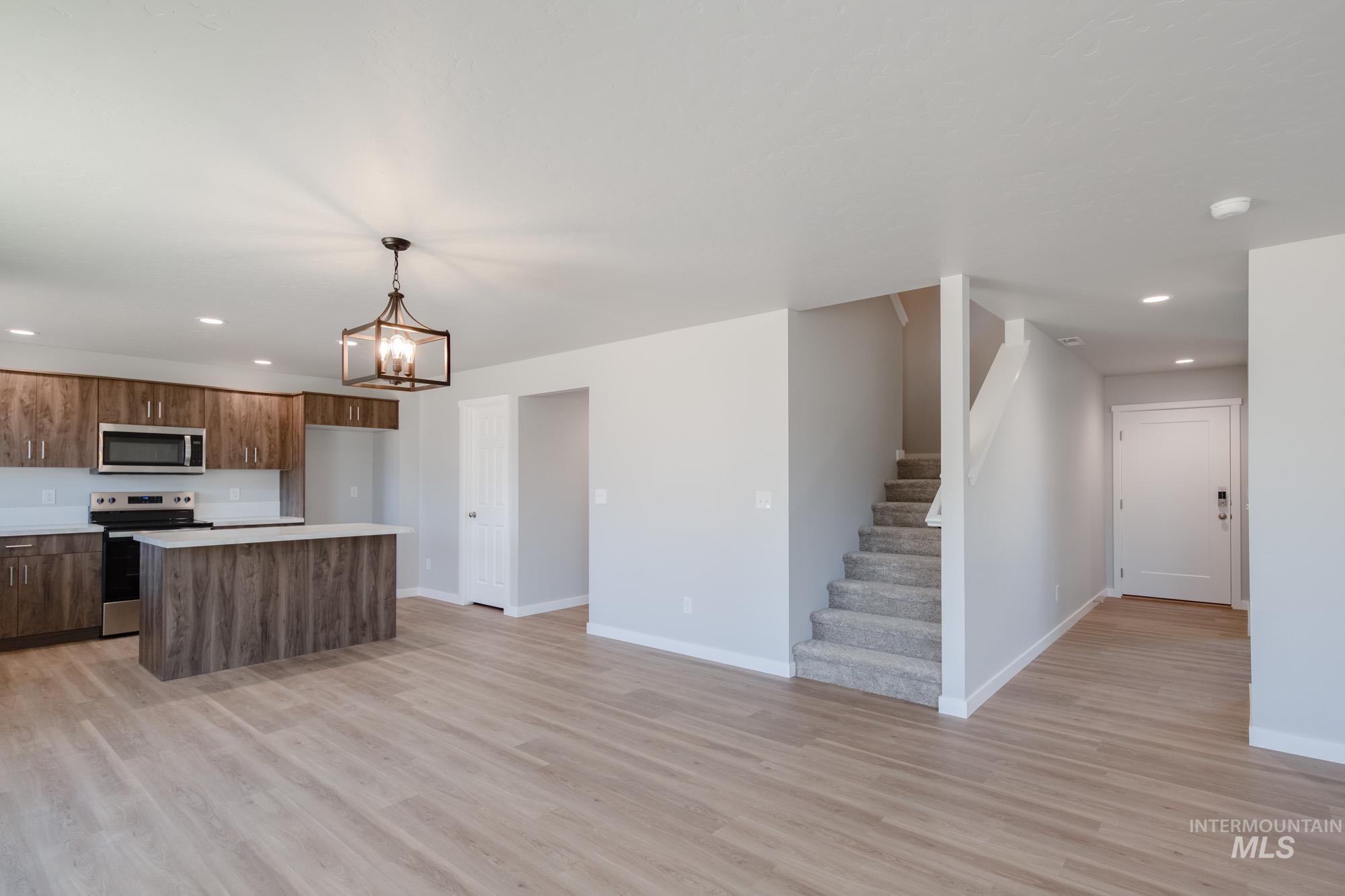 Kitchen featuring recessed lighting, a center island, stainless steel appliances, light countertops, and decorative light fixtures