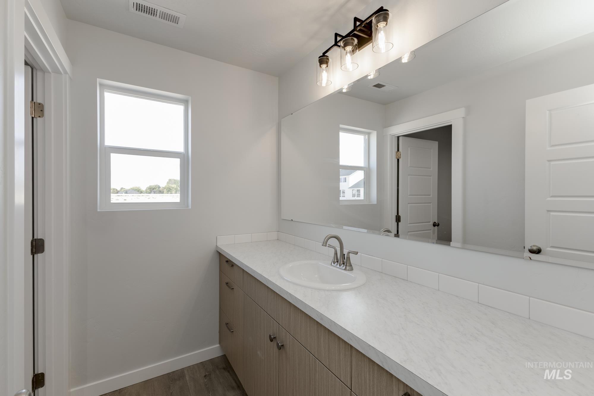 Bathroom featuring vanity and dark wood-style flooring