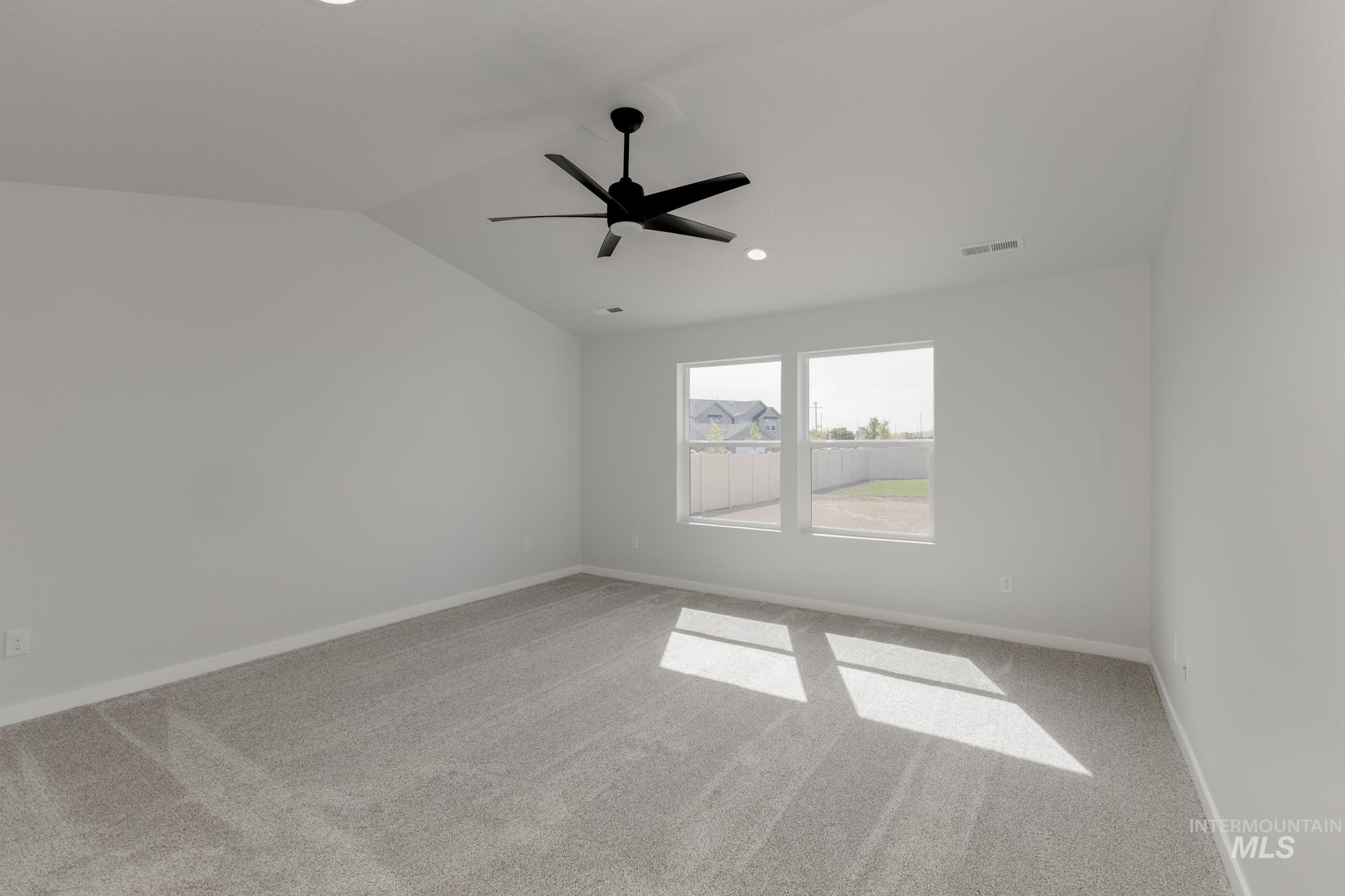 Empty room with light carpet, vaulted ceiling, a ceiling fan, and recessed lighting