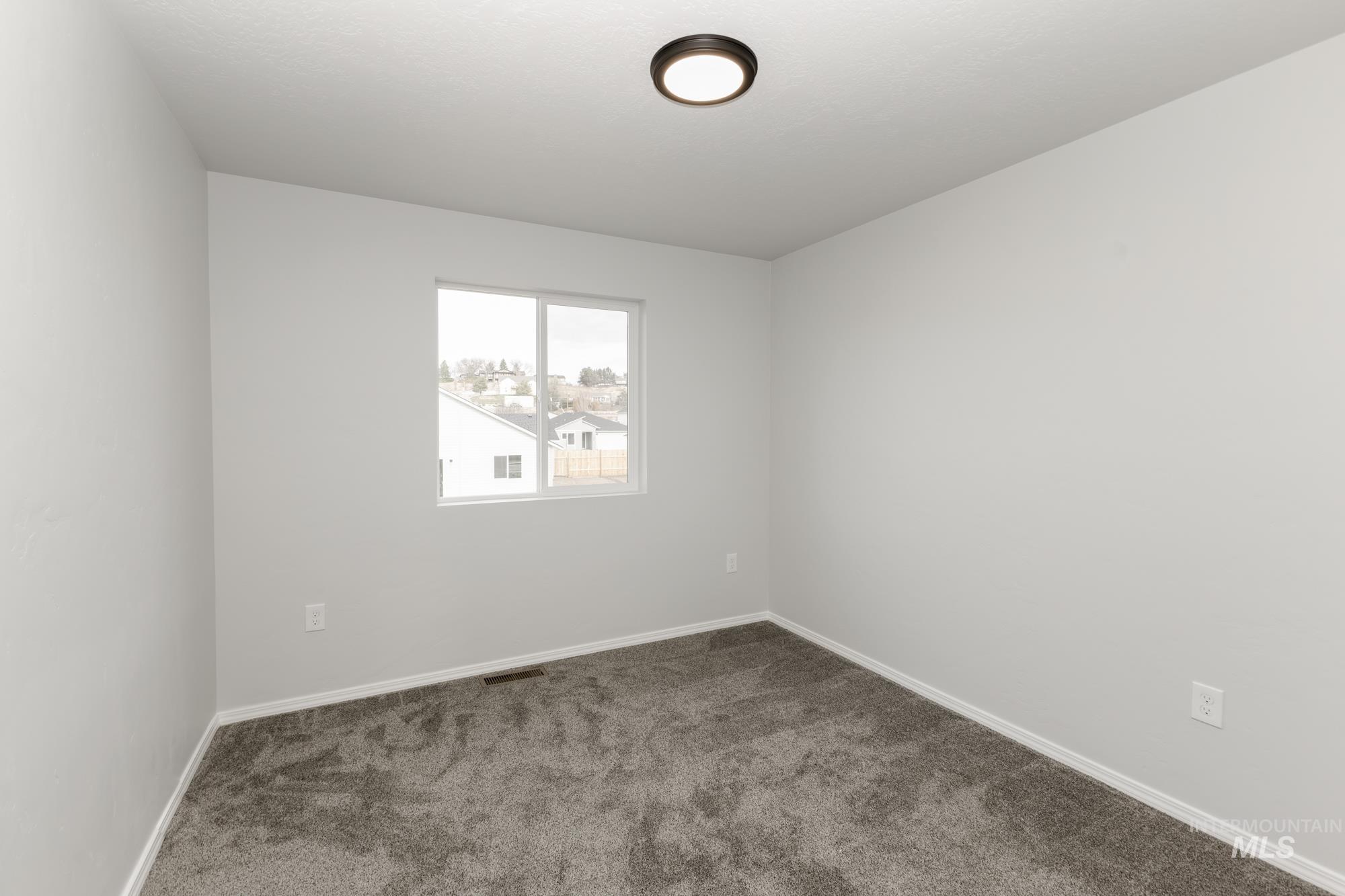 Carpeted empty room with baseboards