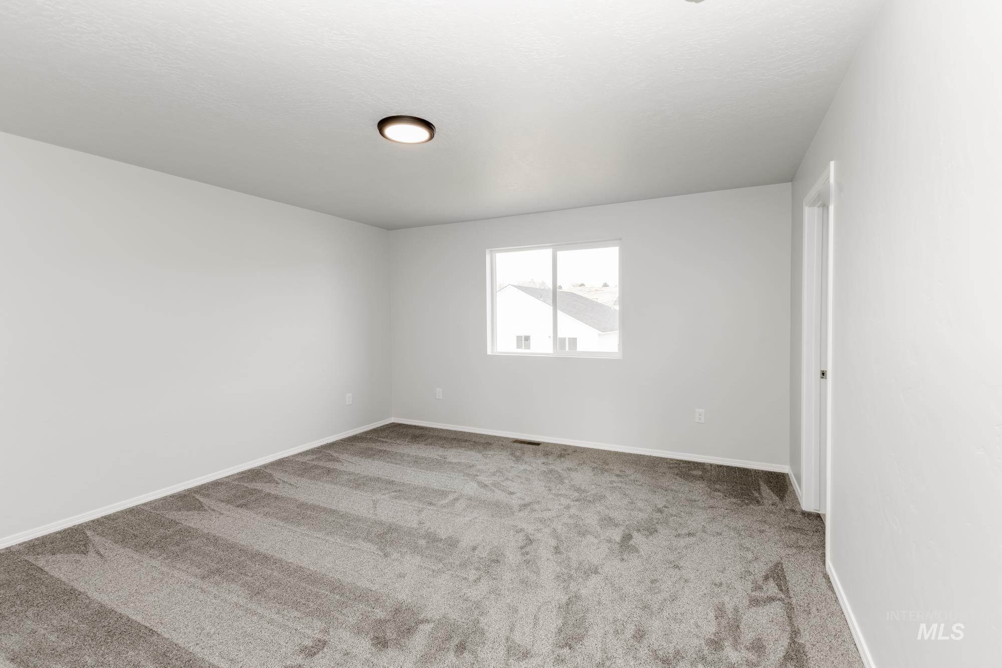 Unfurnished room featuring light colored carpet and baseboards