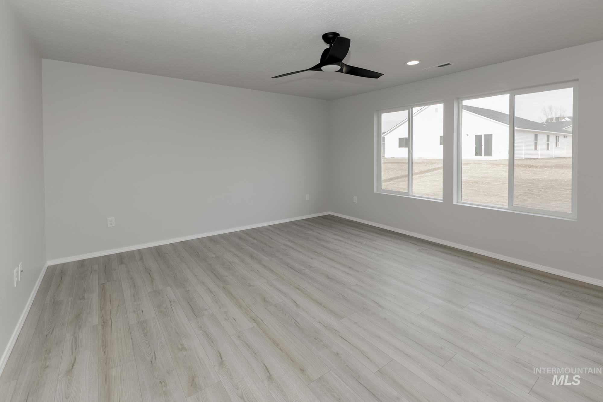 Spare room with light wood-type flooring and a ceiling fan