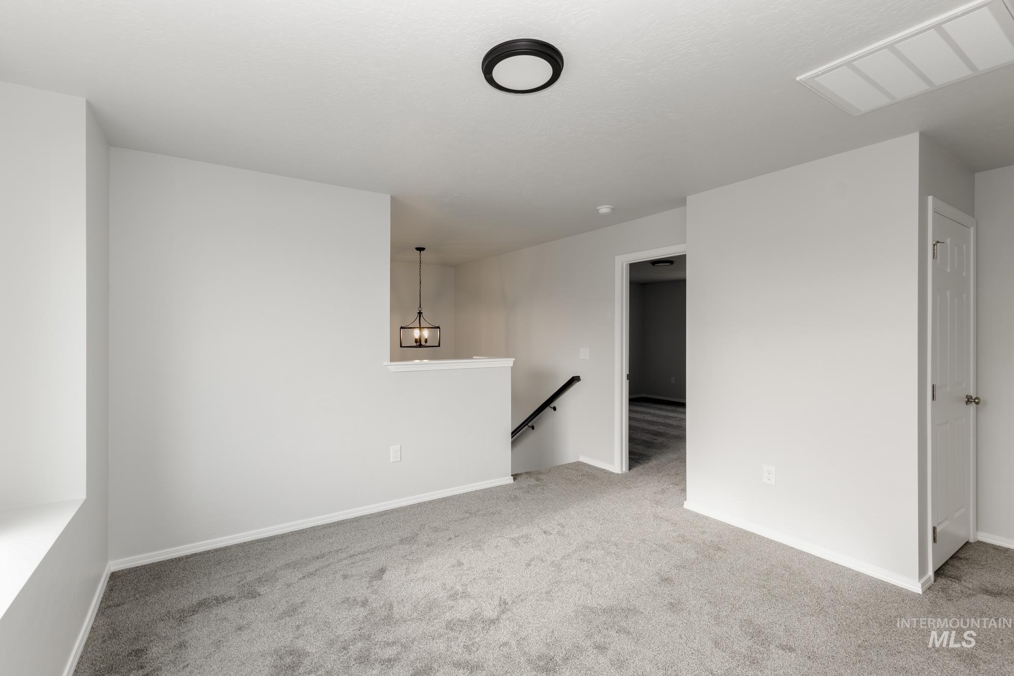Spare room with light carpet and baseboards