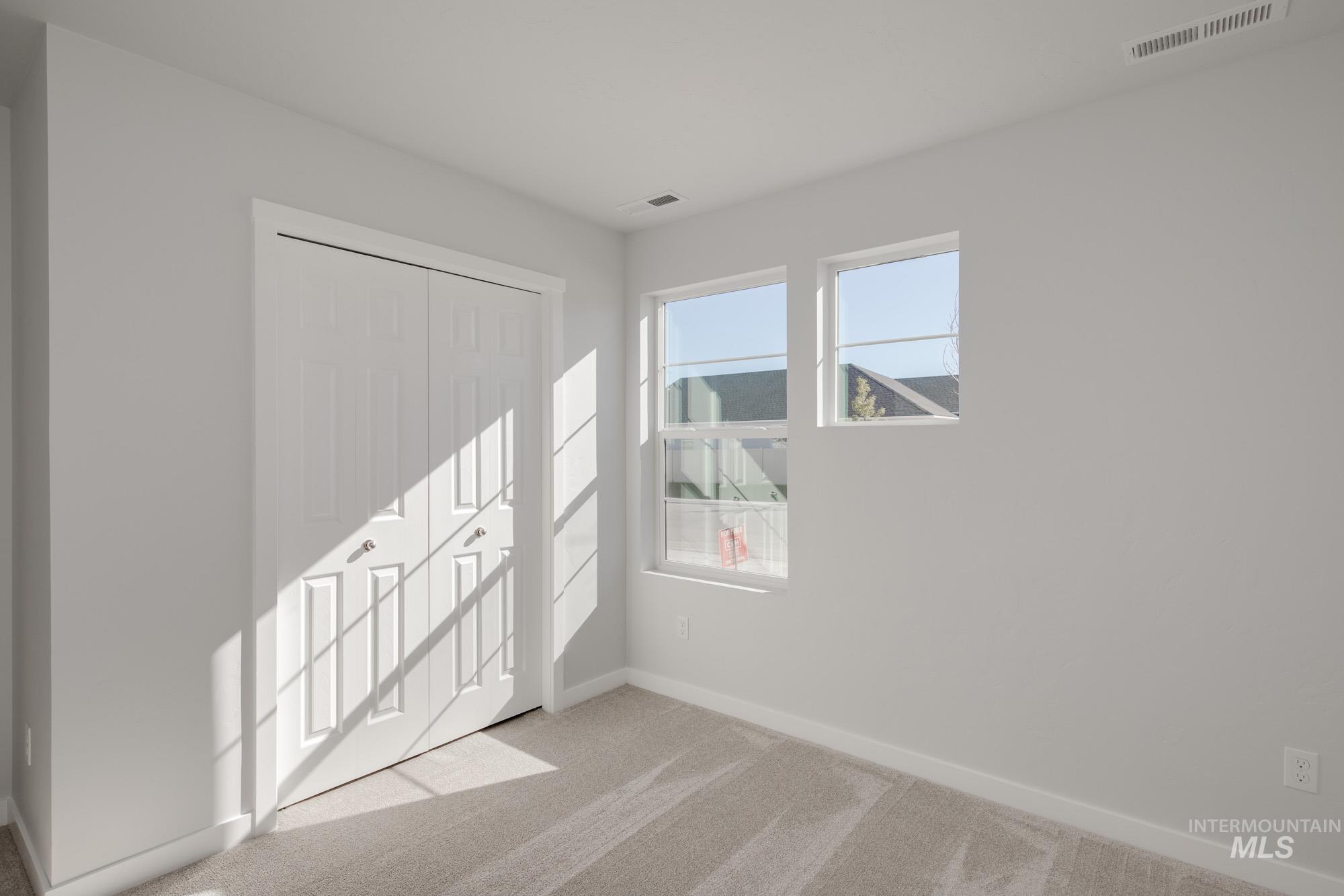 Unfurnished bedroom featuring light colored carpet and a closet