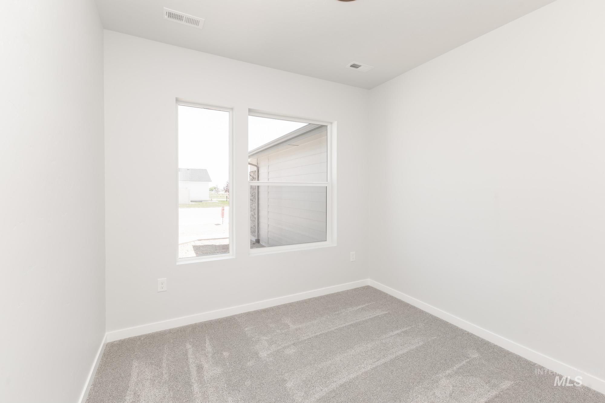Spare room featuring baseboards and carpet floors