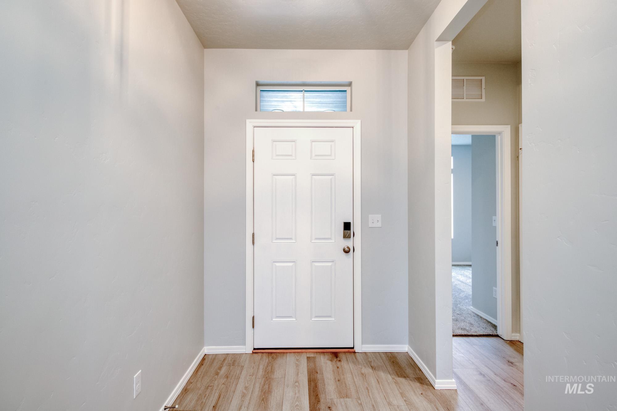 Entryway with light wood-type flooring and baseboards