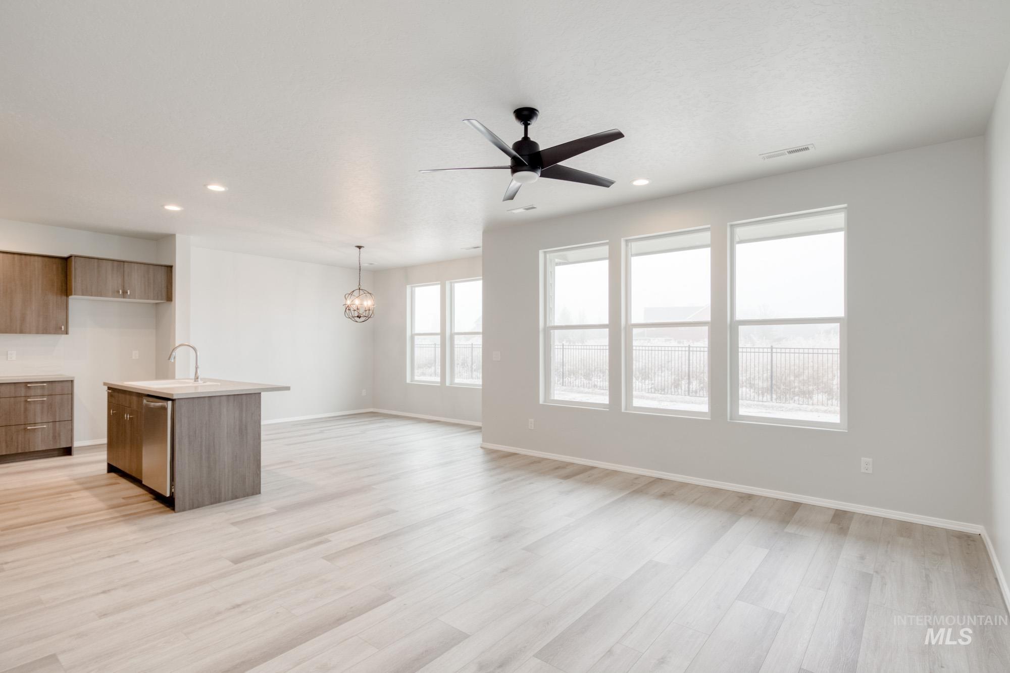 Kitchen featuring a center island with sink, a ceiling fan, recessed lighting, modern cabinets, and light wood-style floors