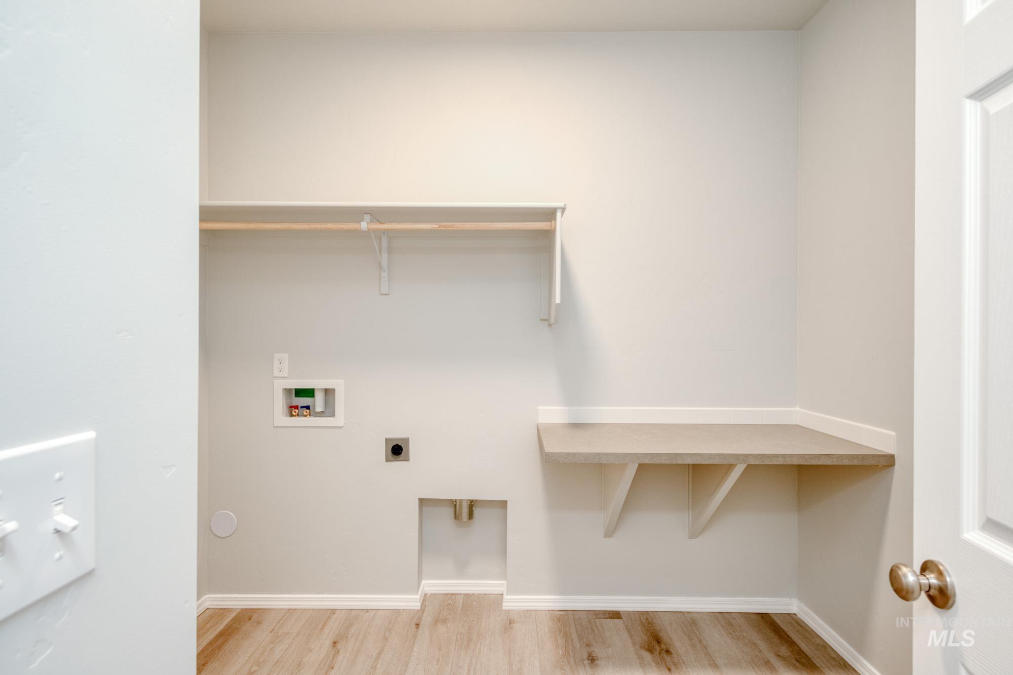 Washroom with light wood finished floors, hookup for an electric dryer, and hookup for a washing machine