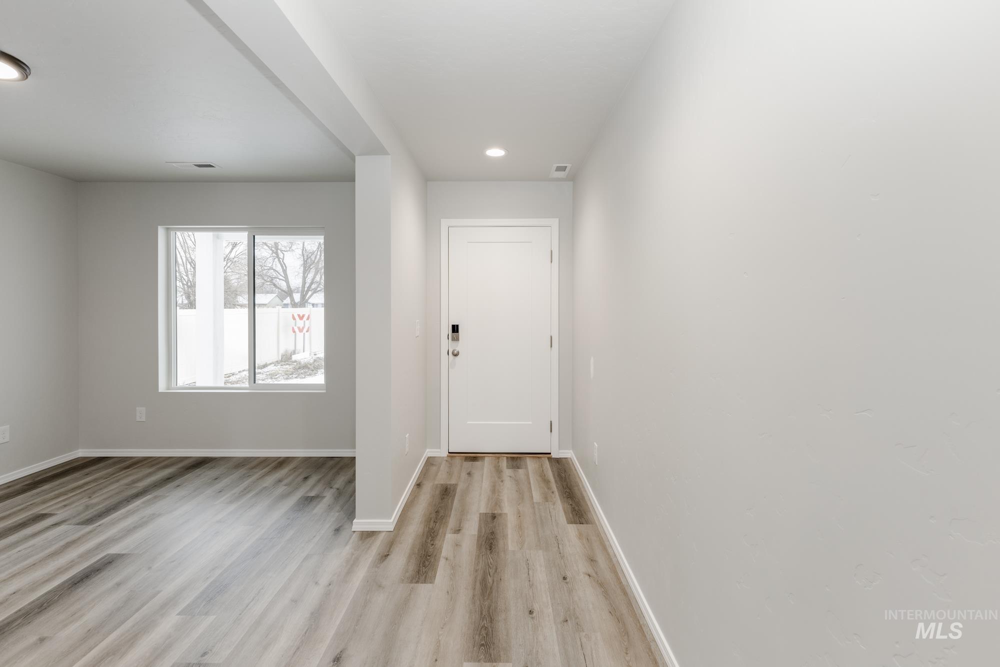 Entryway with wood finished floors and recessed lighting