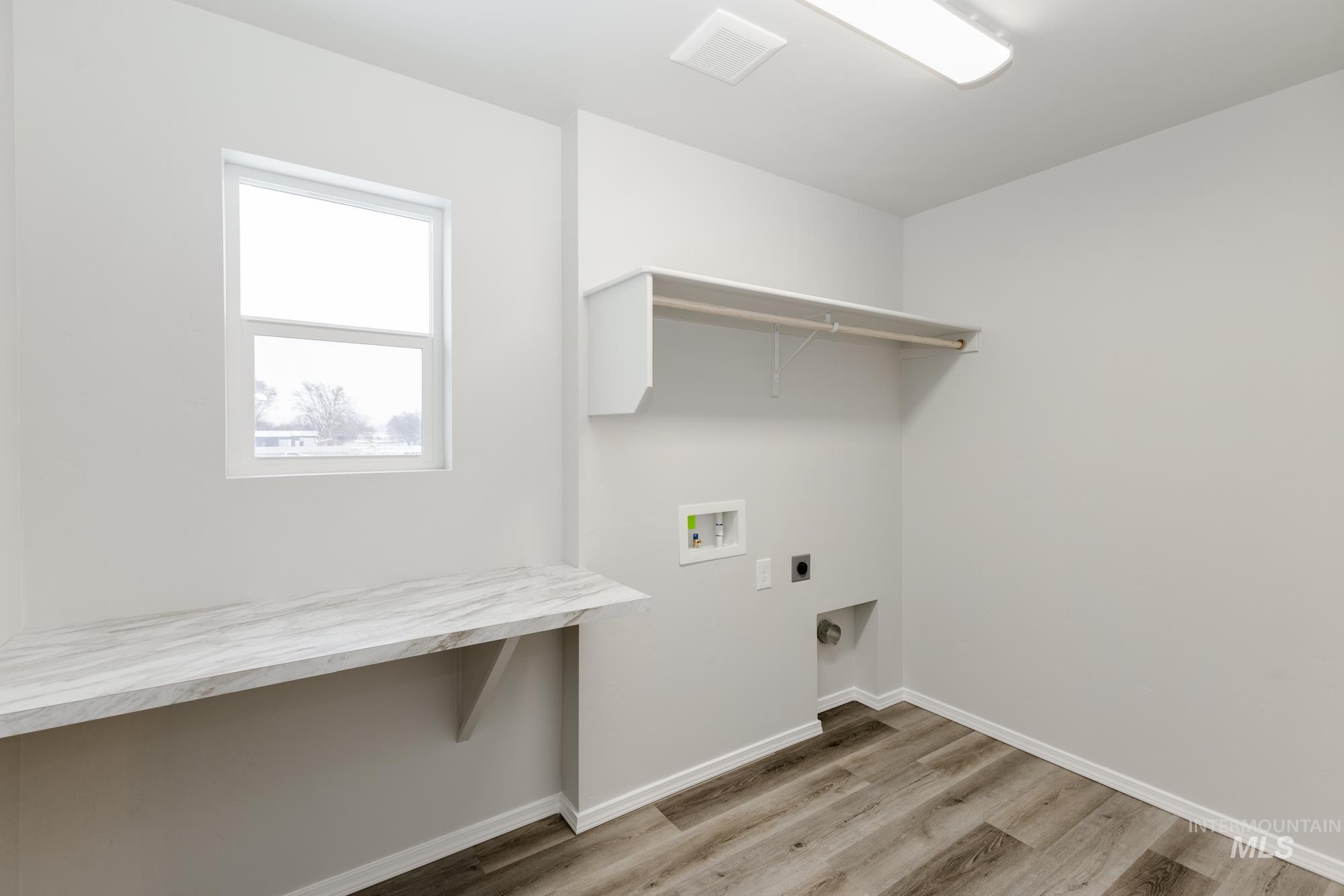 Laundry area featuring light wood finished floors, electric dryer hookup, and hookup for a washing machine