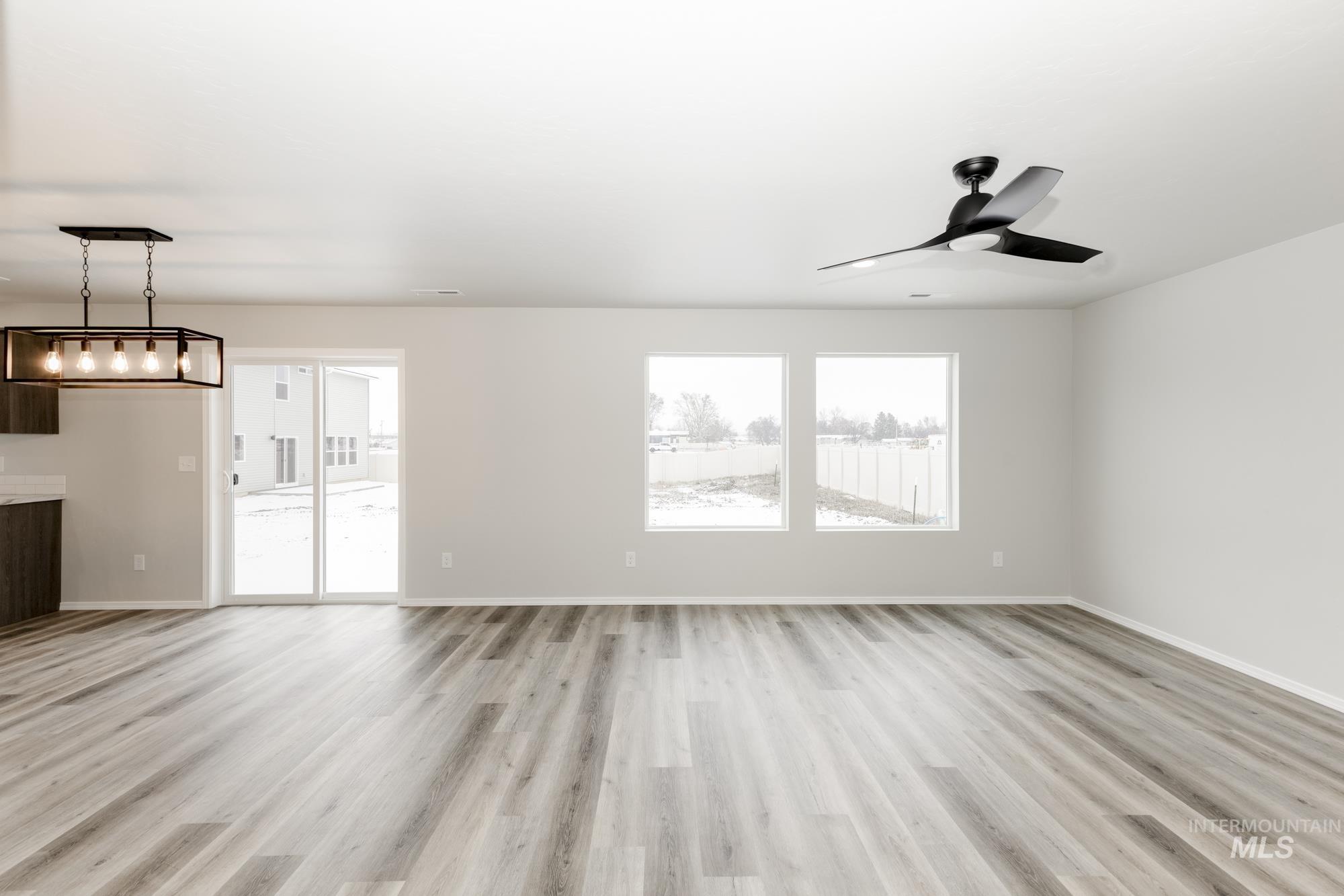 Unfurnished living room featuring light wood-style floors and a ceiling fan