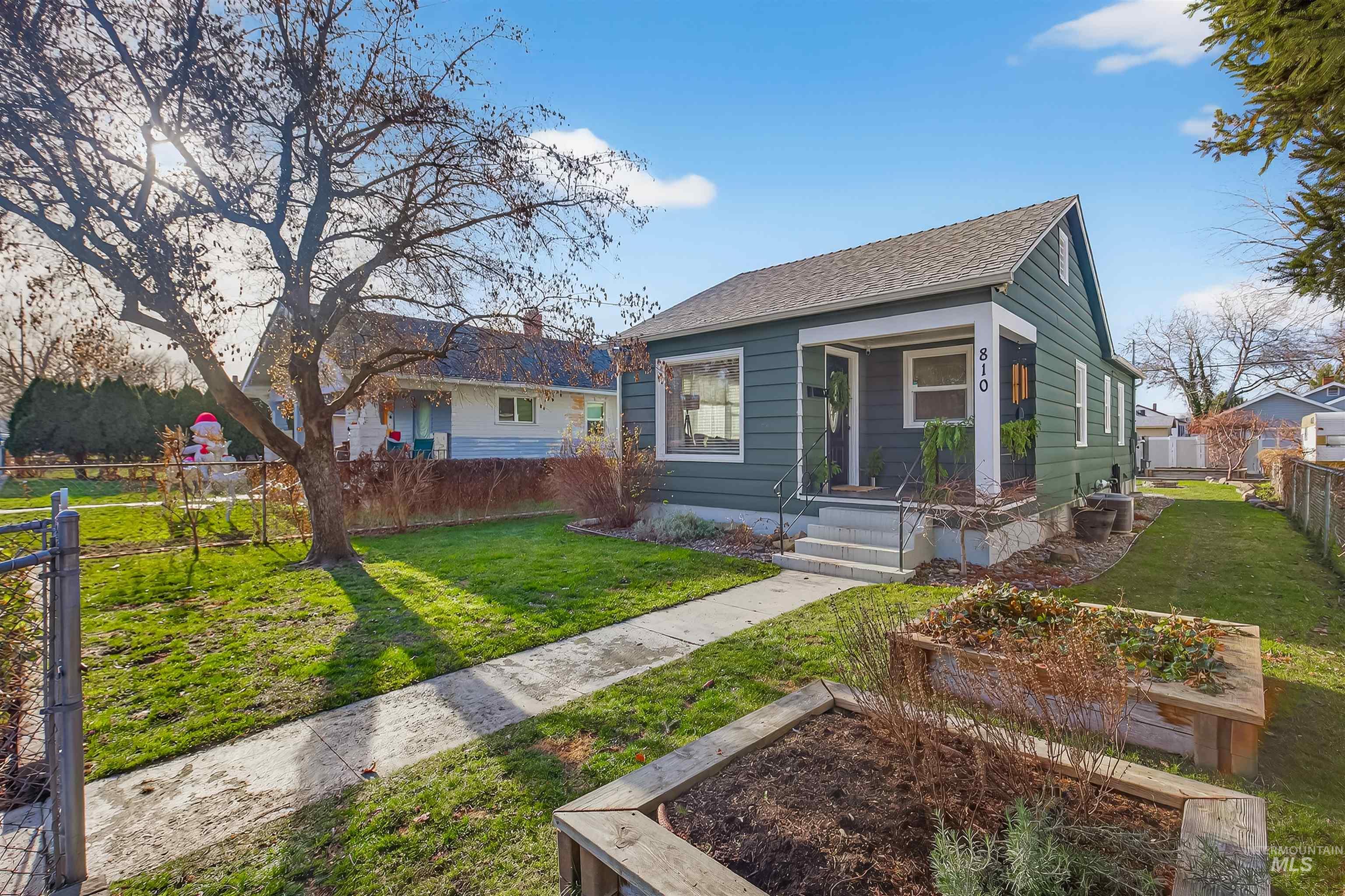 Bungalow featuring a garden and a shingled roof
