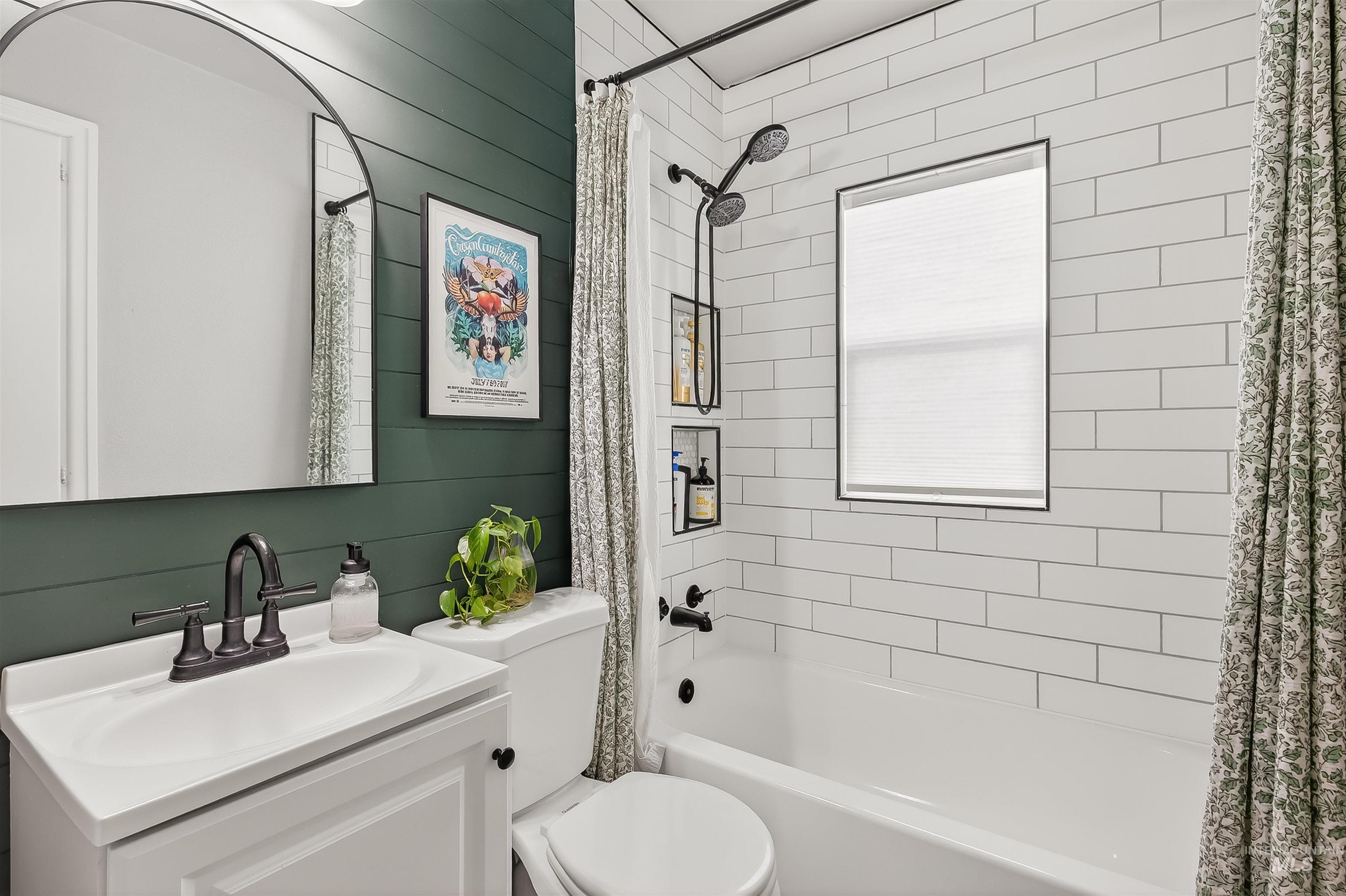Full bath with shower / bath combo with shower curtain, vanity, and wood walls