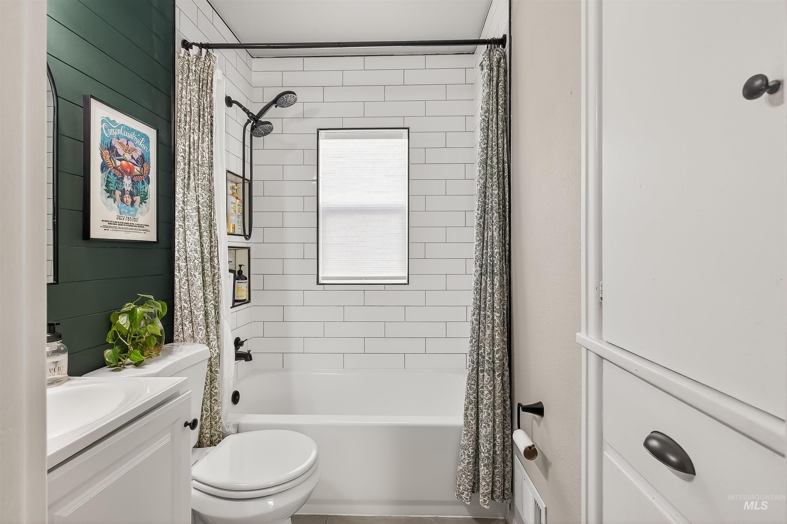 Full bathroom featuring shower / bath combo, vanity, and wooden walls