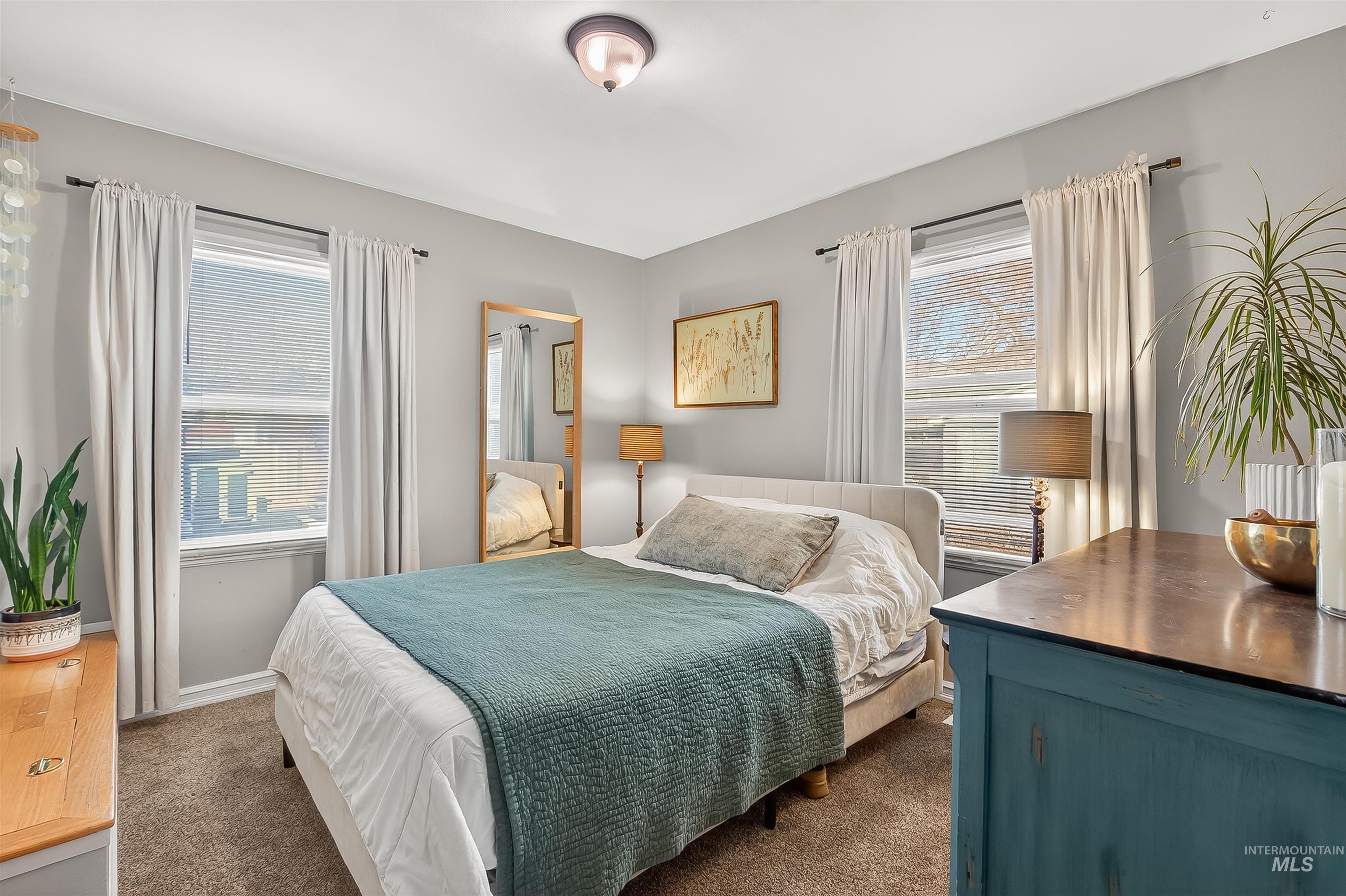 Carpeted bedroom featuring multiple windows