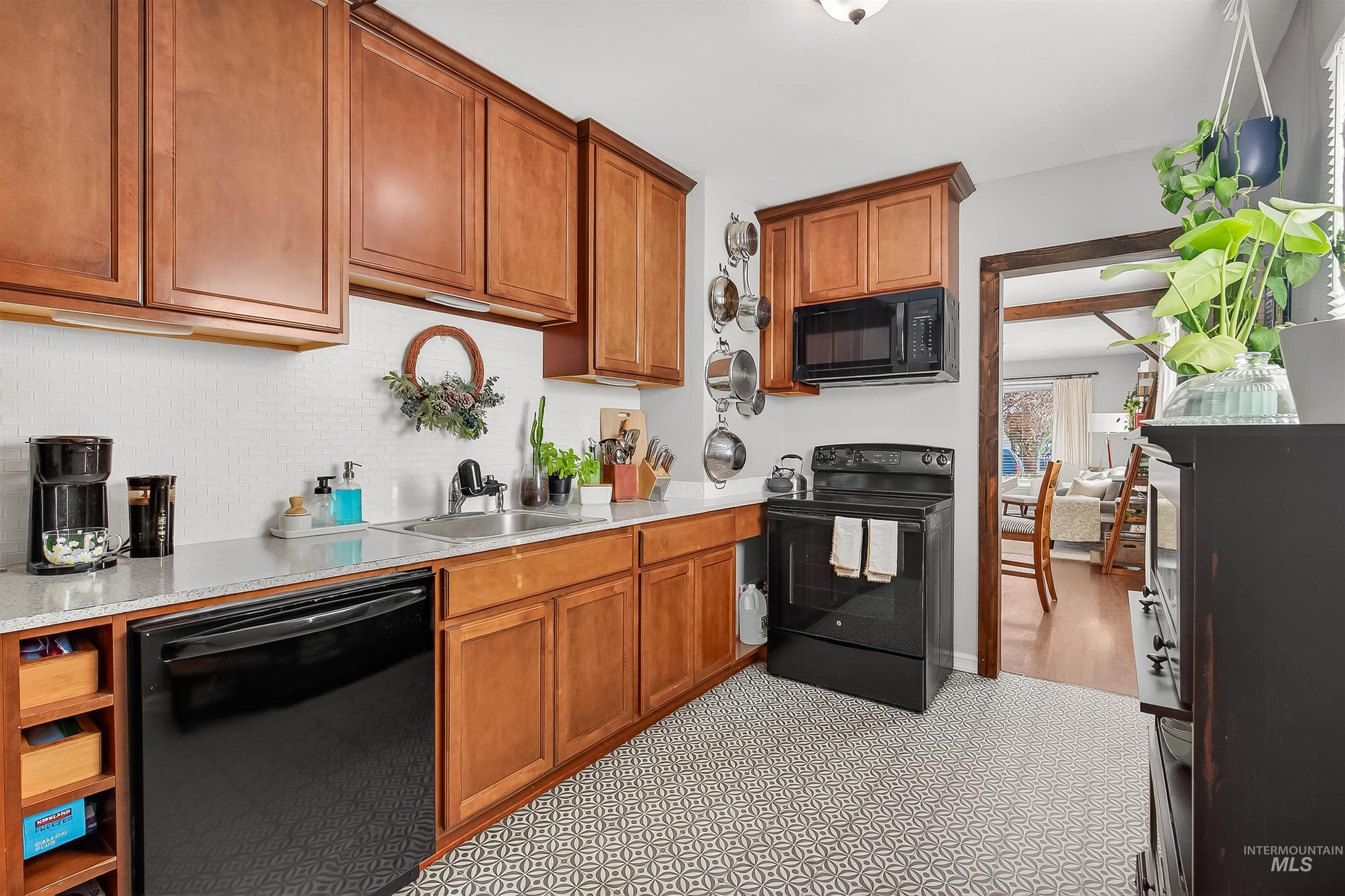 Kitchen featuring black appliances and brown cabinetry