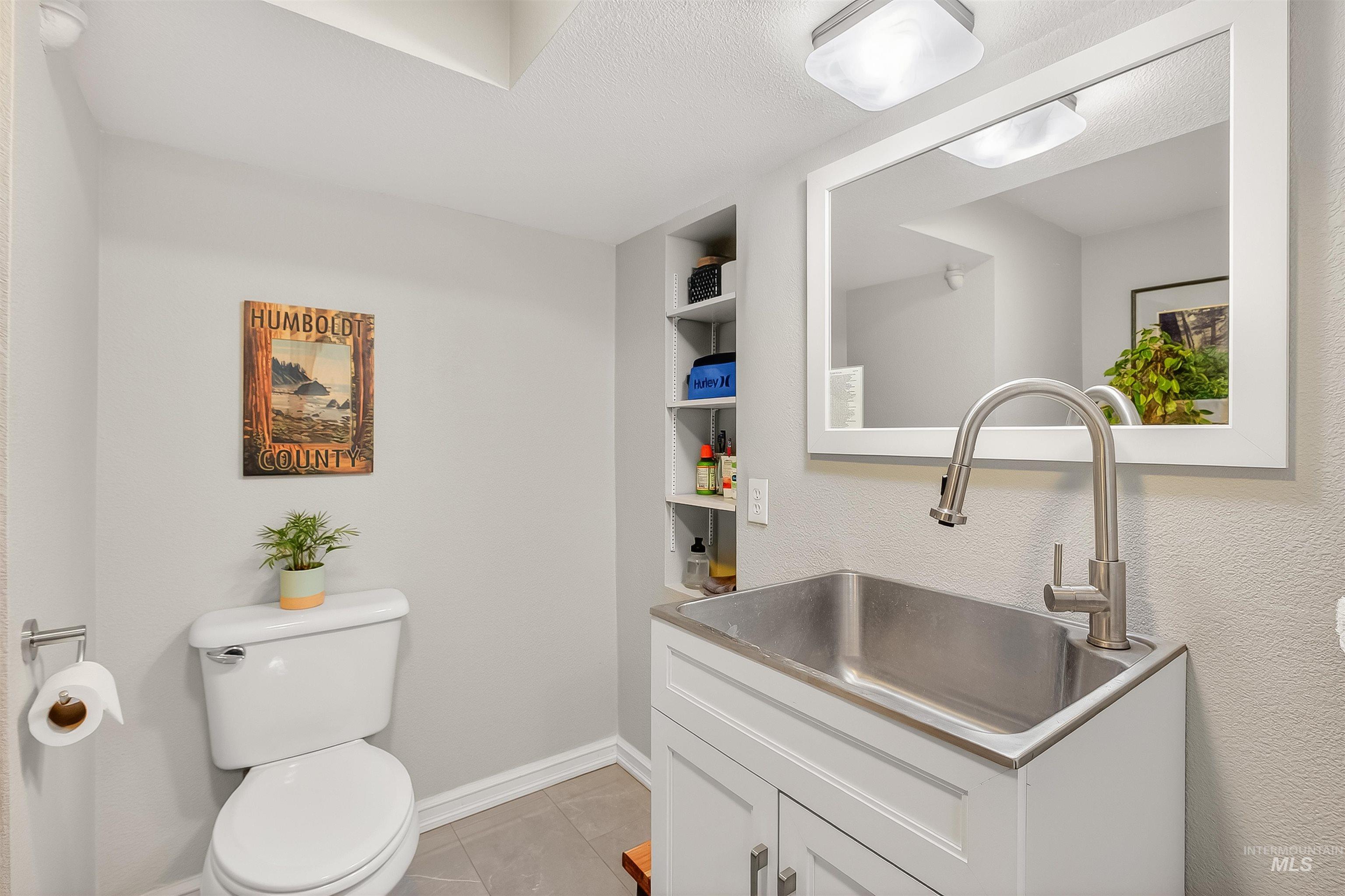 Half bathroom with vanity, light tile patterned floors, and built in features