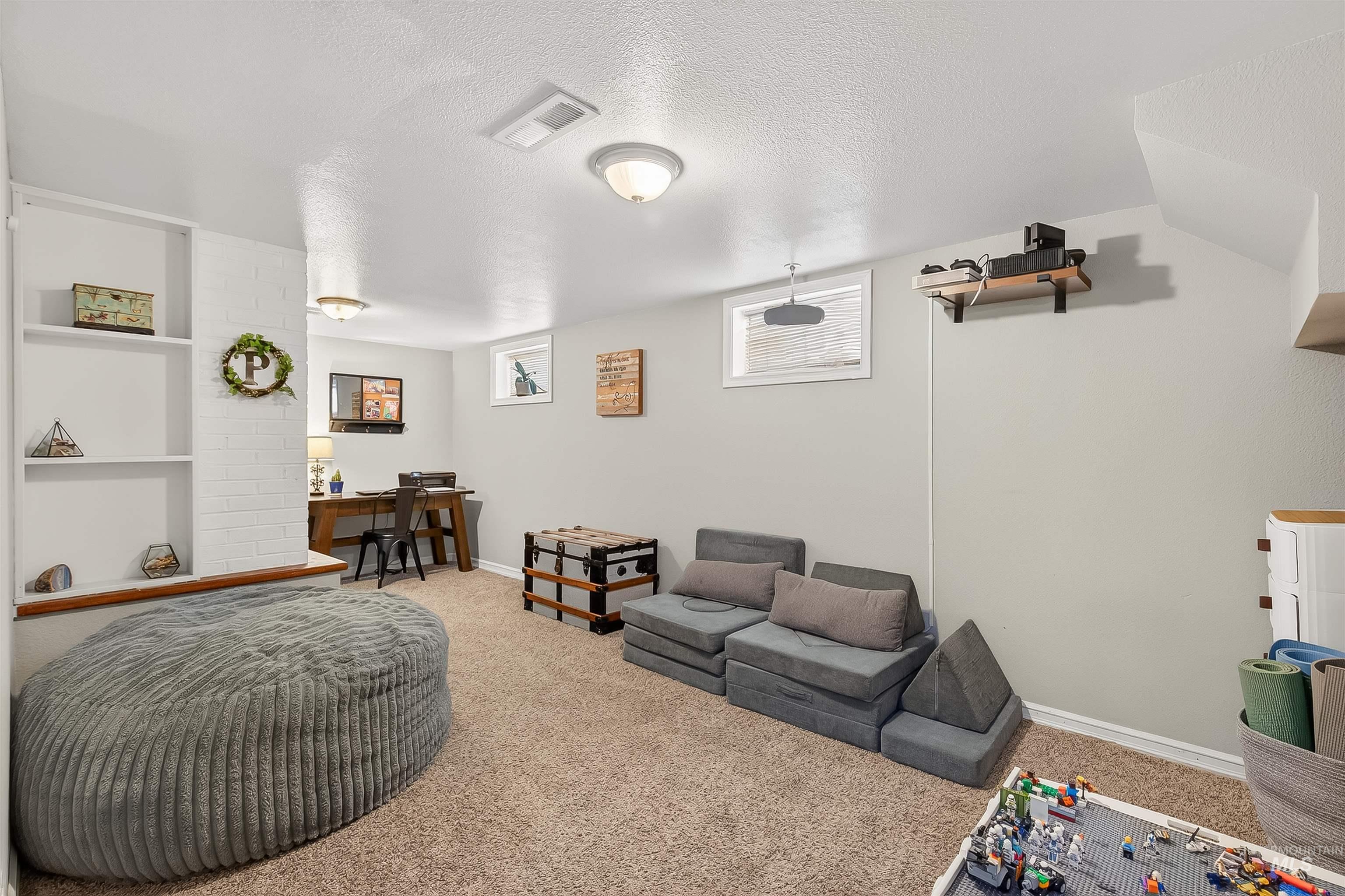 Carpeted living area featuring a textured ceiling and an office area