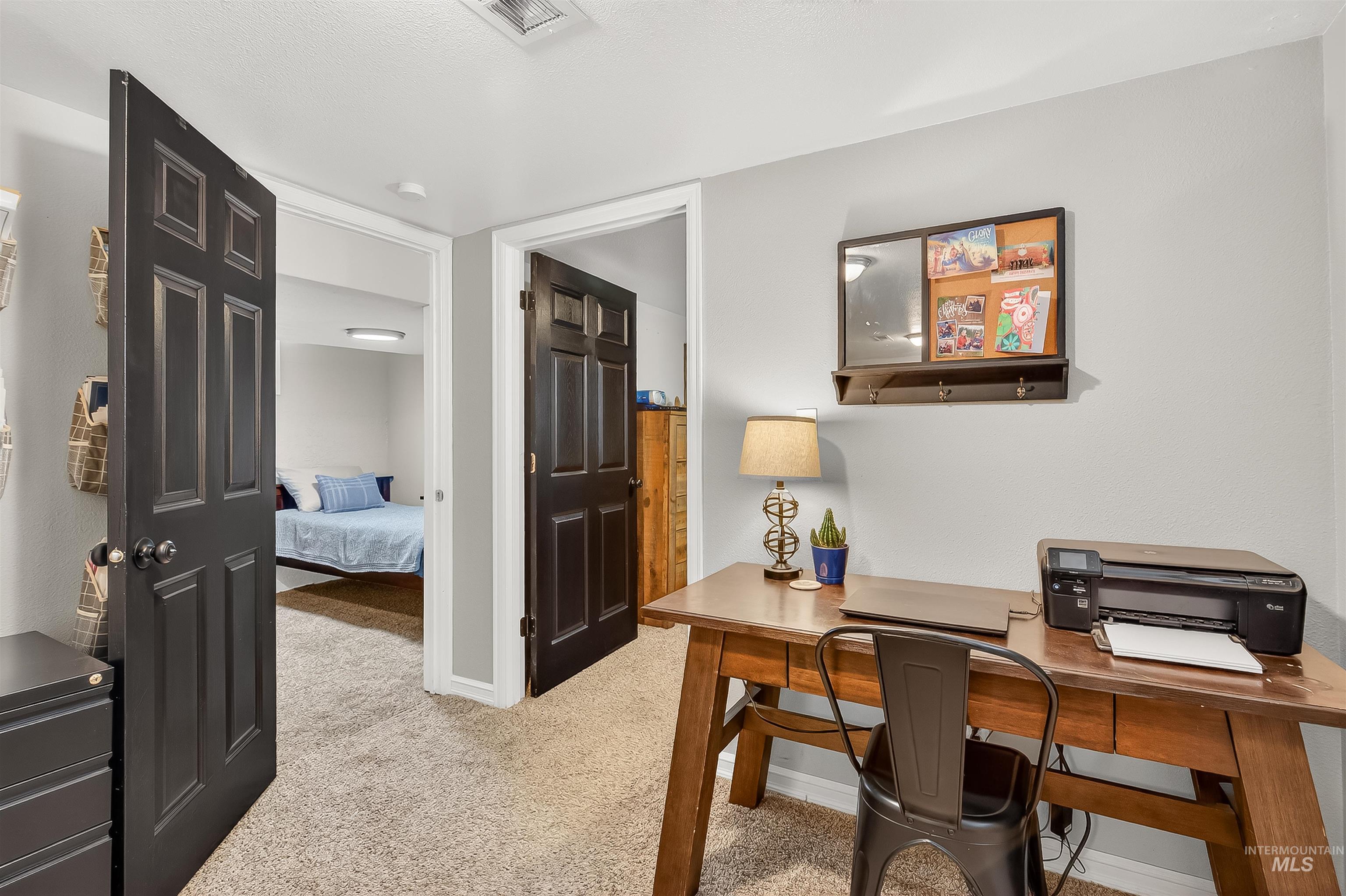 Home office featuring light colored carpet and baseboards