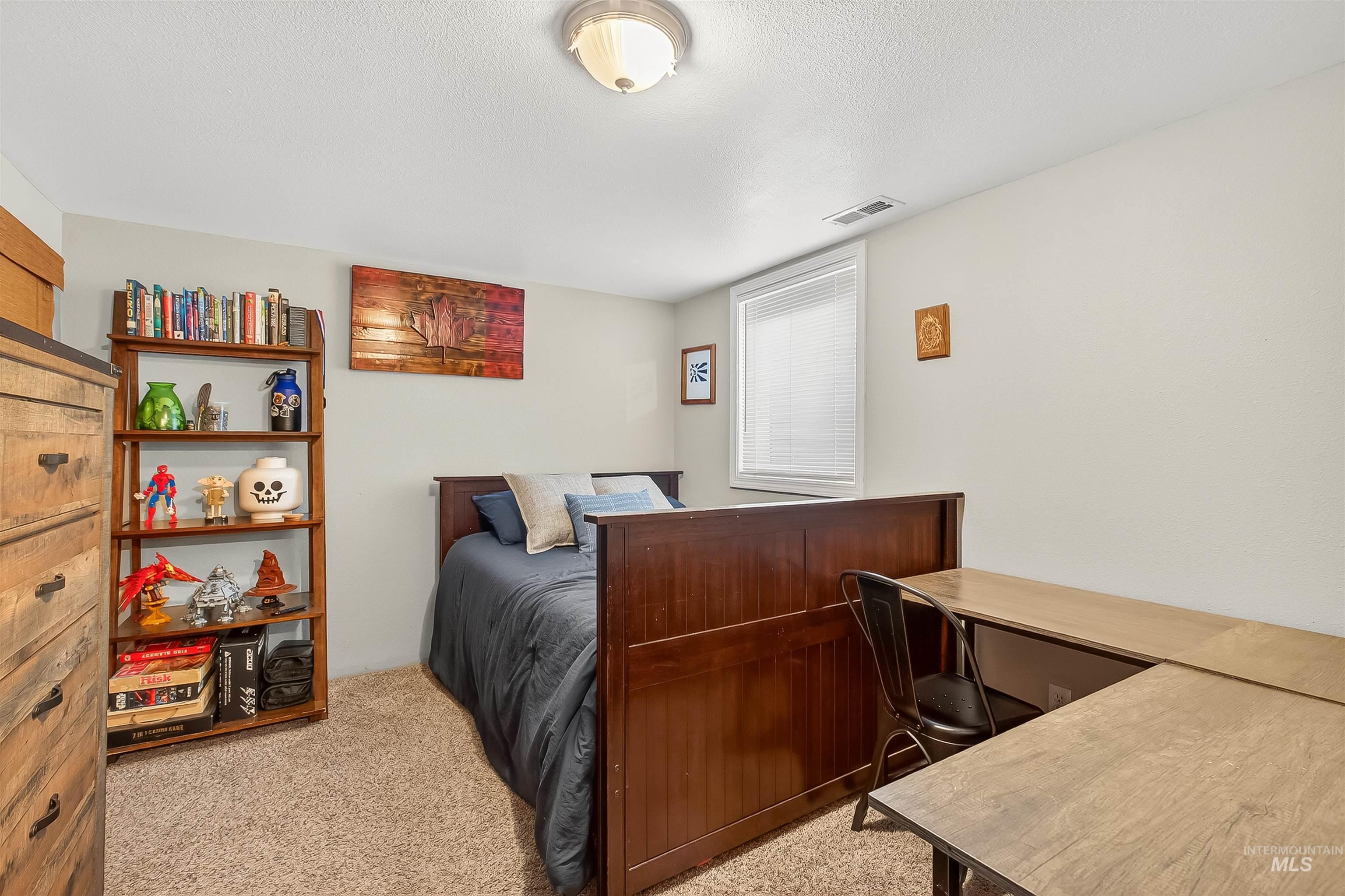 Bedroom featuring light carpet and a textured ceiling