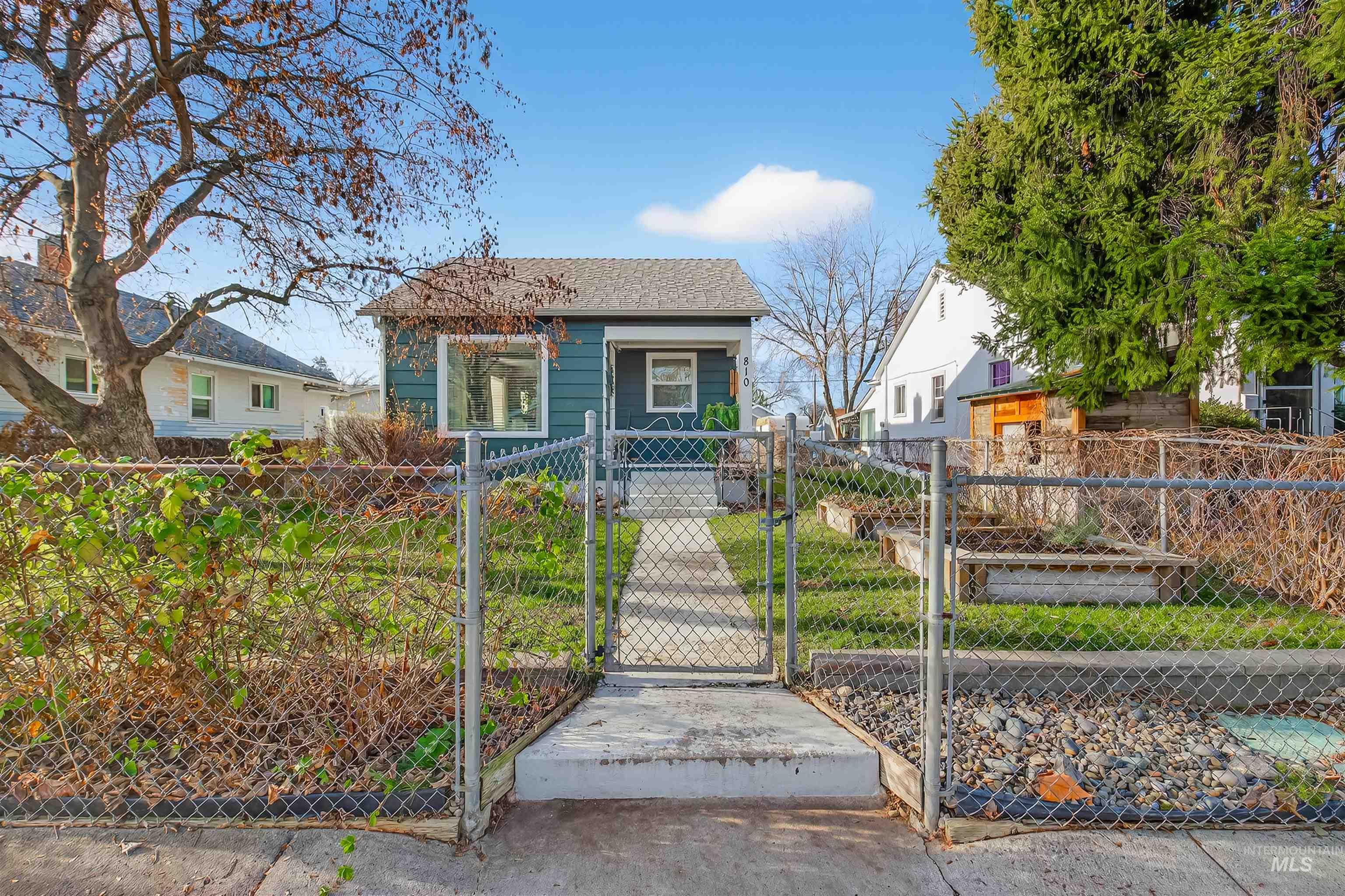 Bungalow-style house with a gate and a fenced front yard