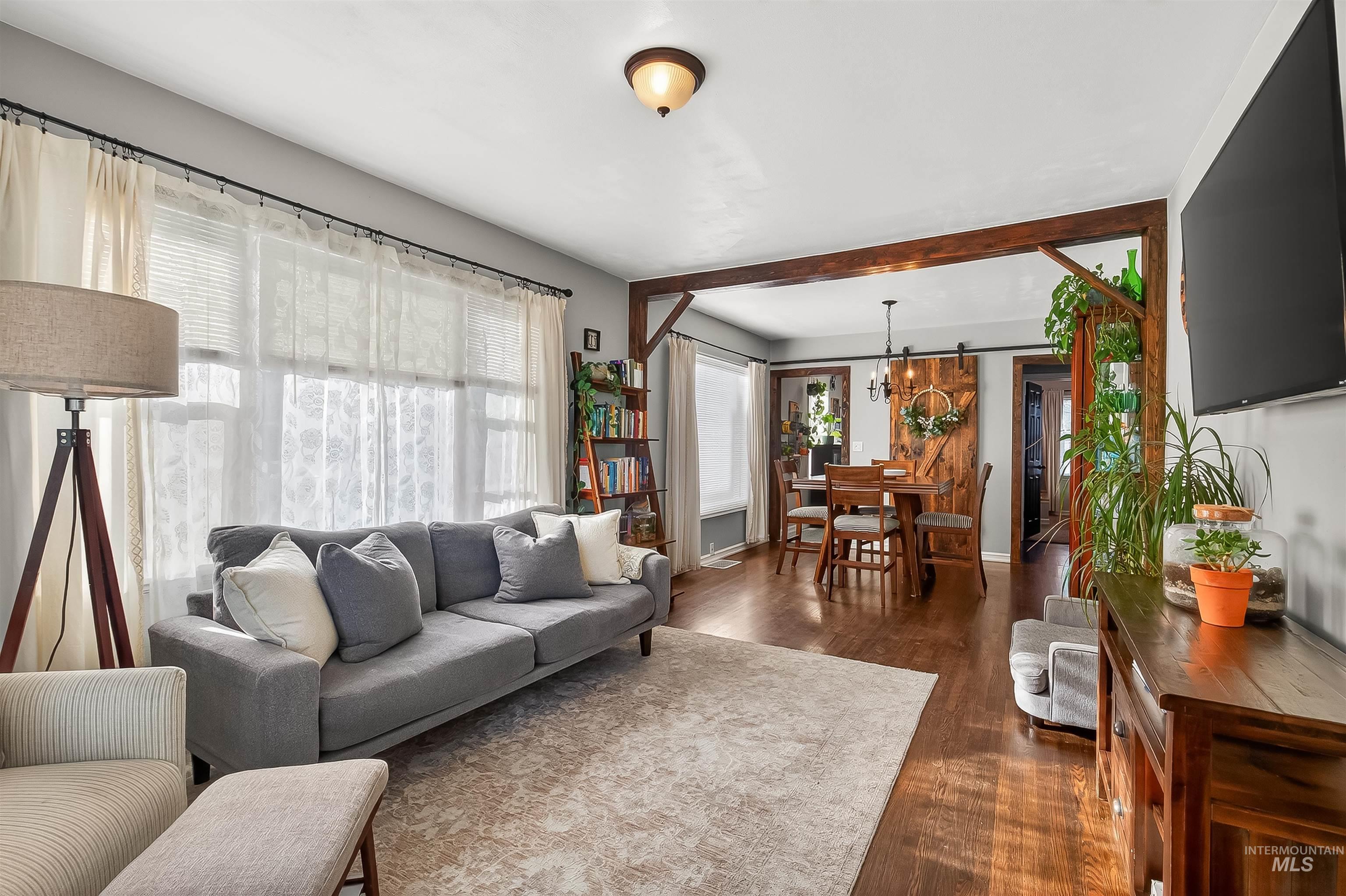 Living area featuring dark wood-style floors and baseboards