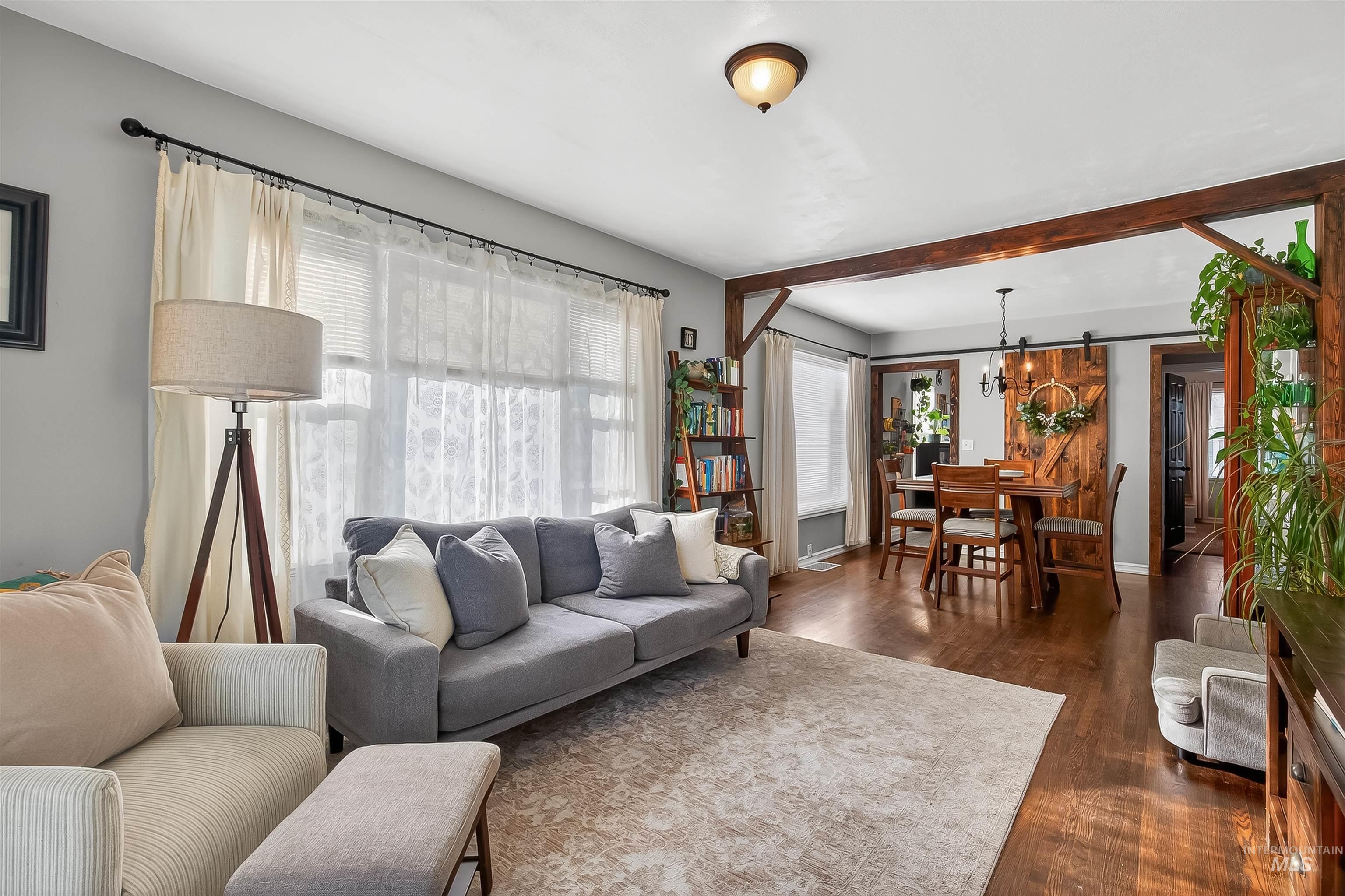Living area featuring a barn door, dark wood-type flooring, and plenty of natural light
