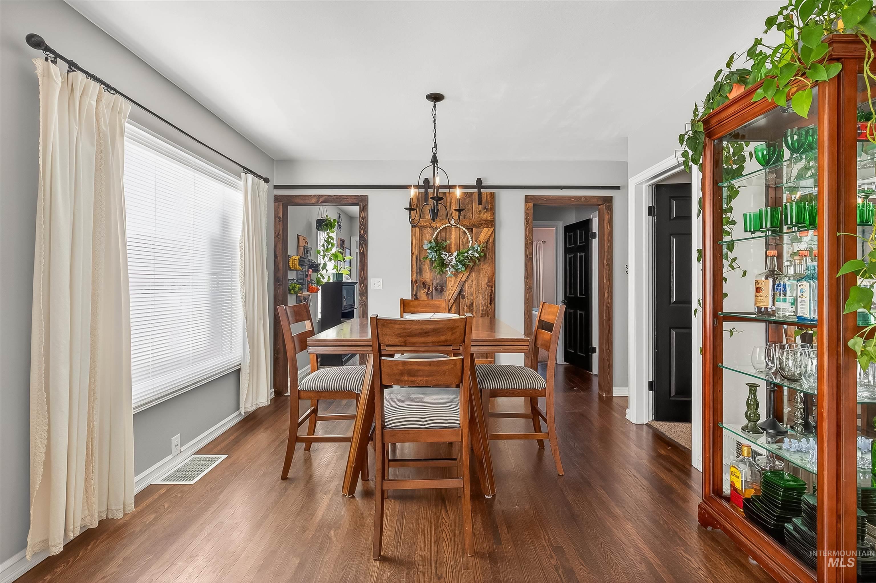 Dining area featuring a barn door and dark wood finished floors