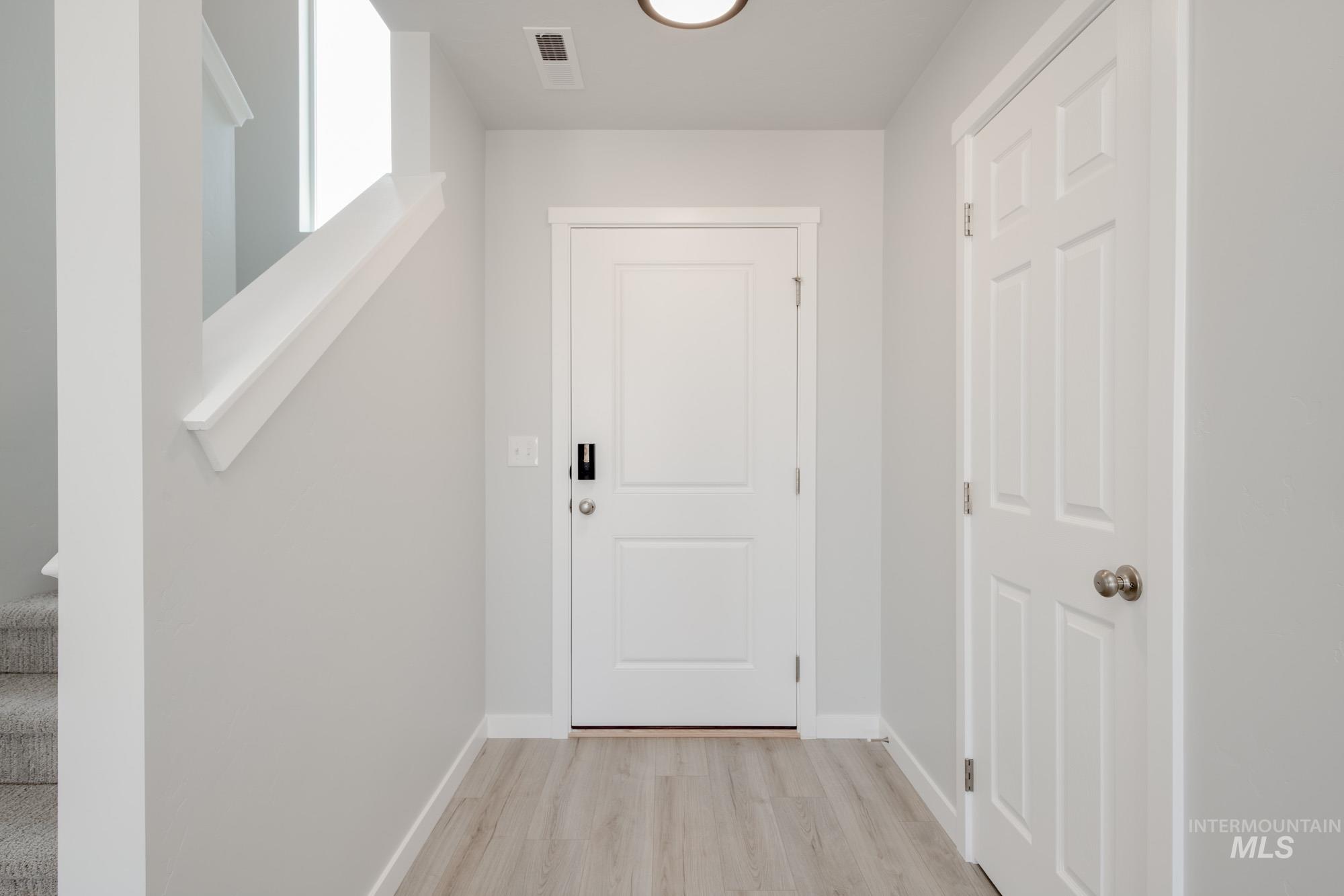 Doorway to outside featuring stairs and wood finished floors