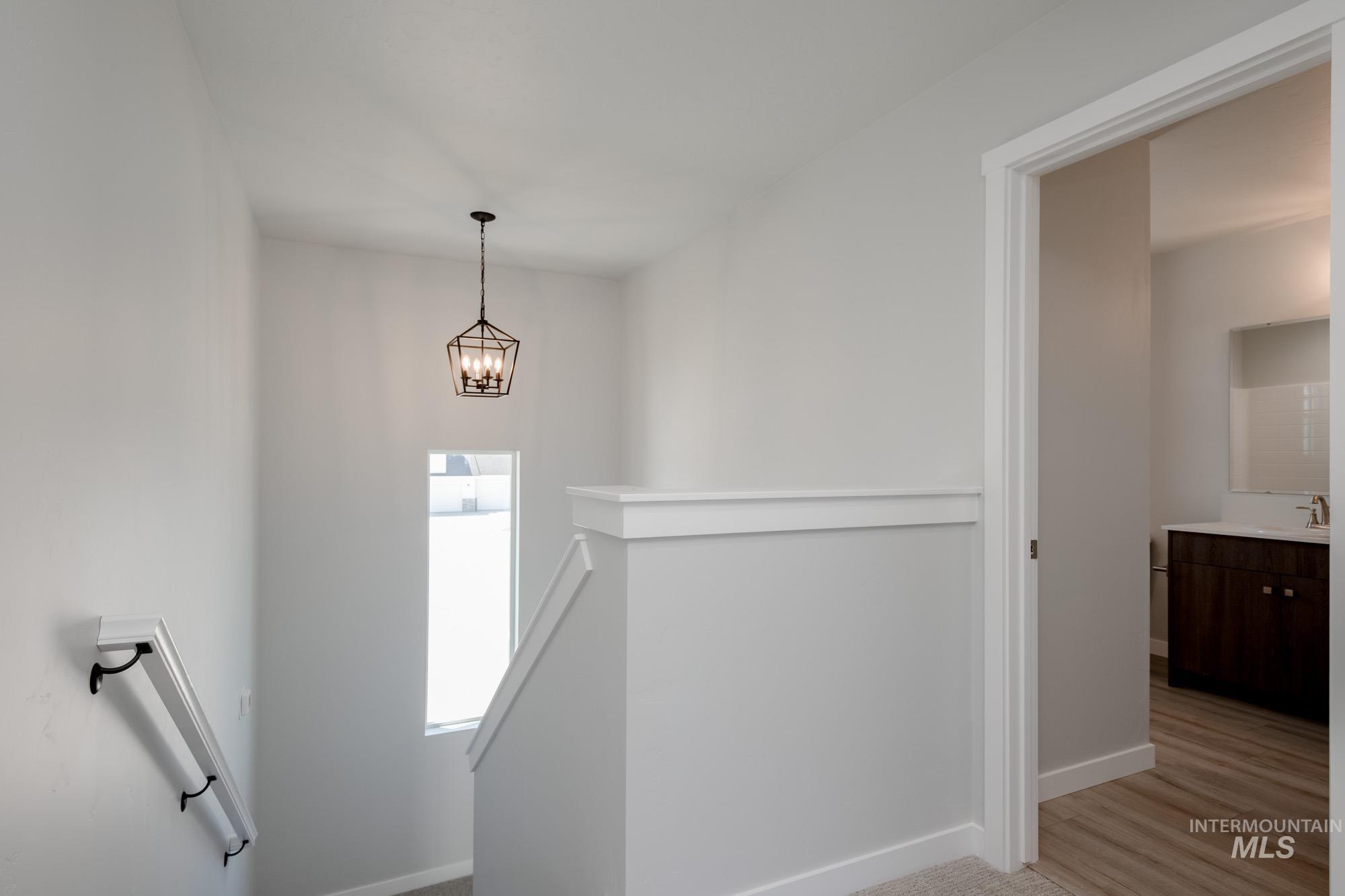 Staircase featuring baseboards and a chandelier