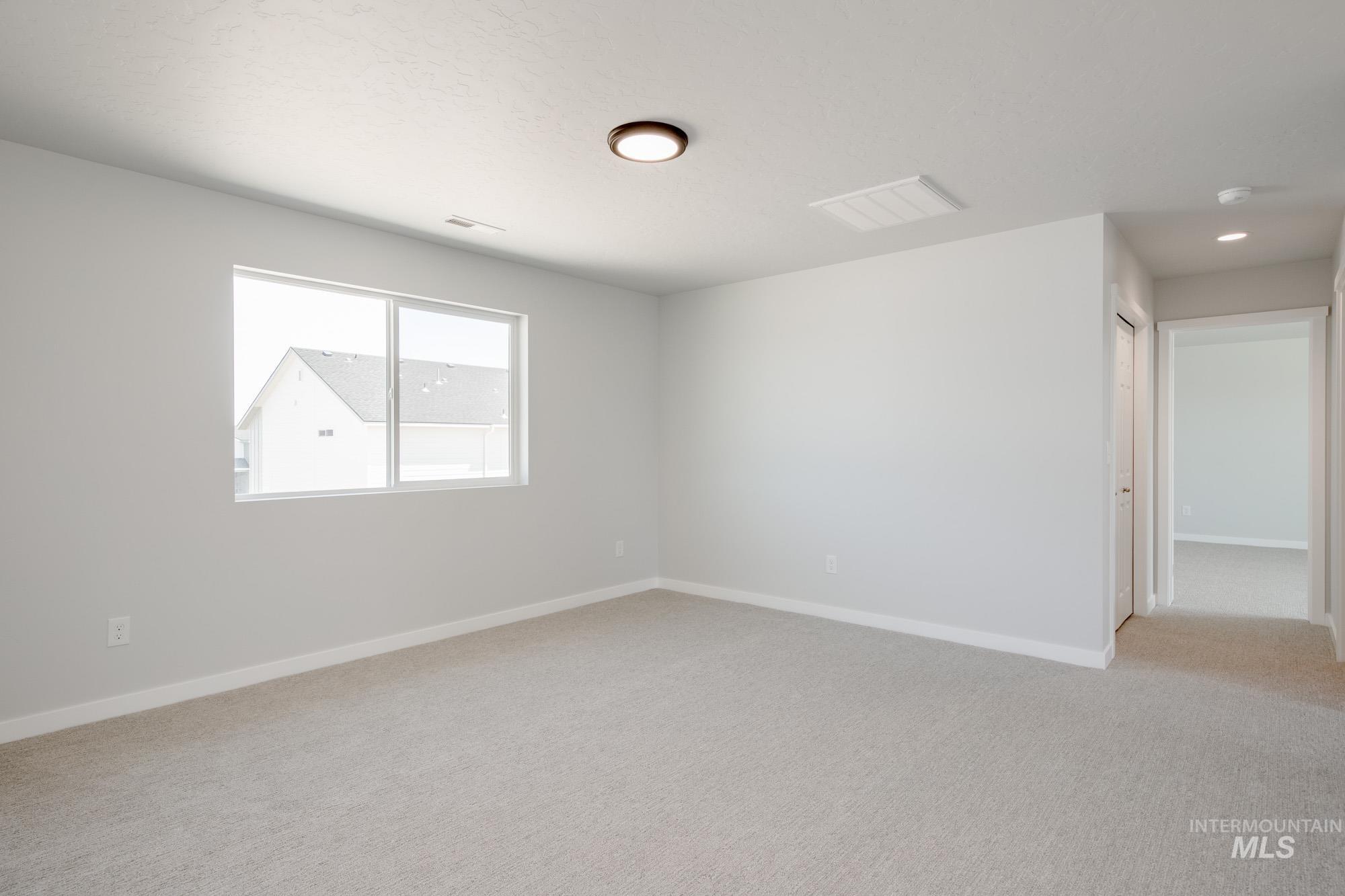 Unfurnished room with baseboards and light carpet
