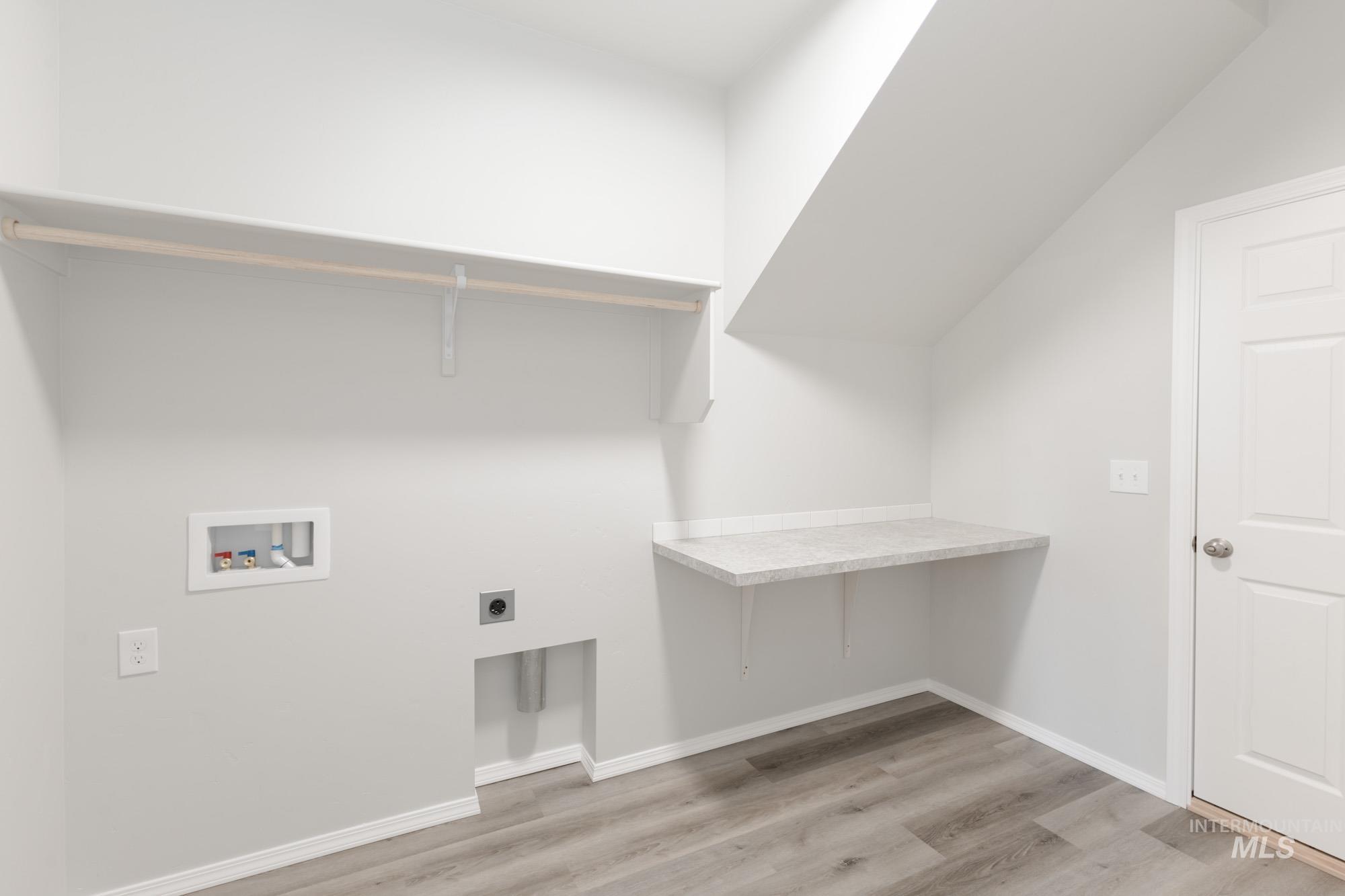 Laundry room featuring light wood-style flooring, hookup for an electric dryer, and washer hookup