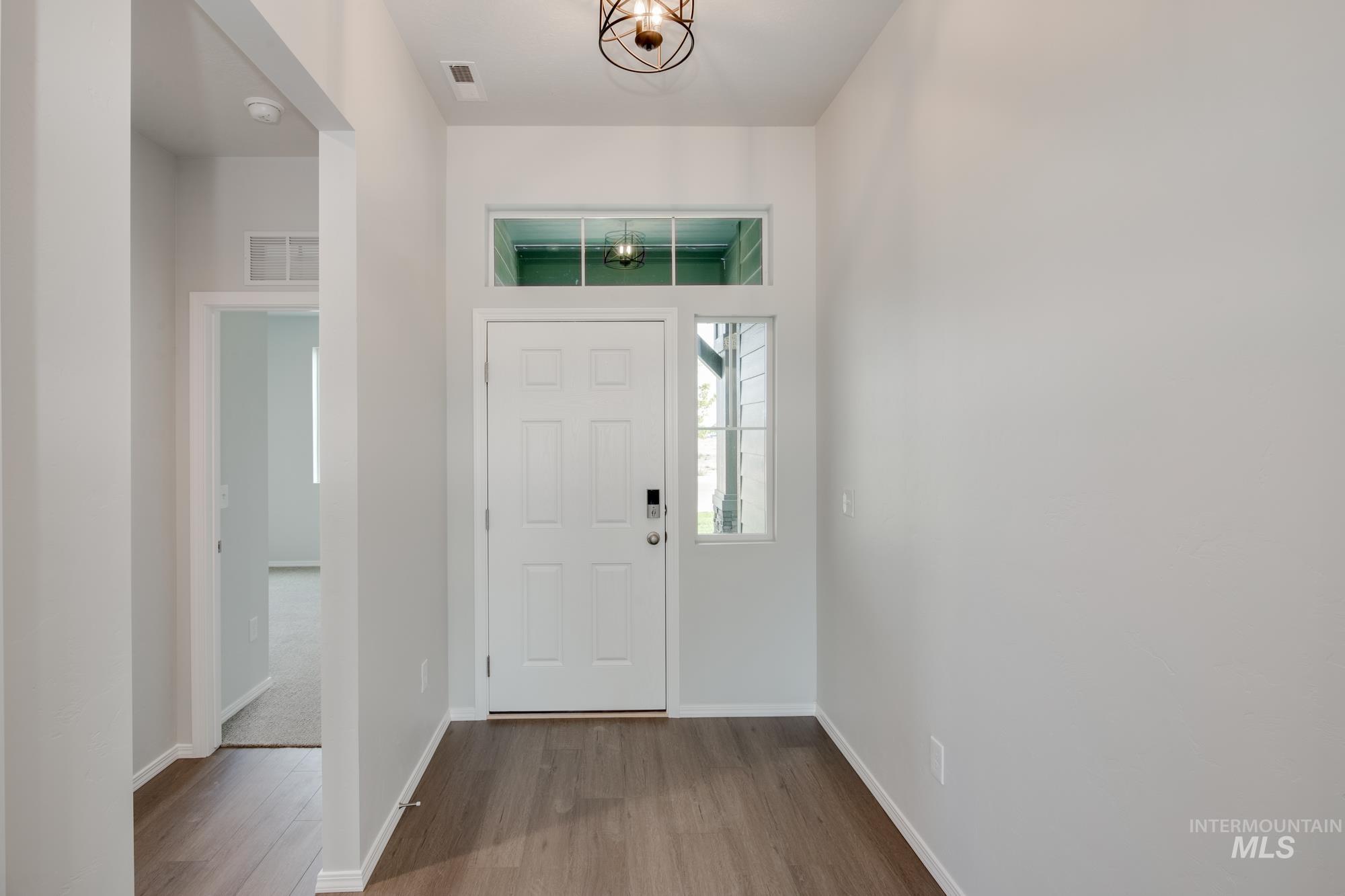 Foyer entrance with wood finished floors and baseboards