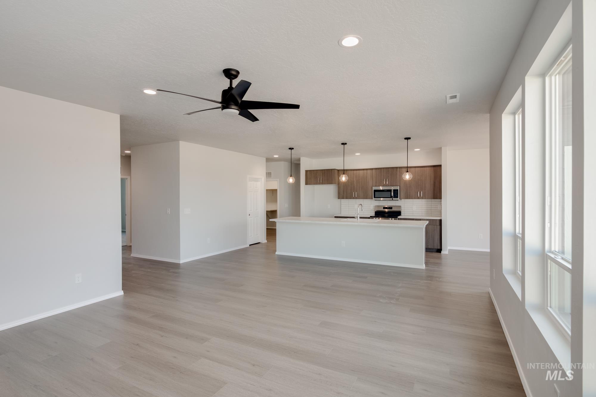 Unfurnished living room with recessed lighting, light wood-type flooring, and ceiling fan