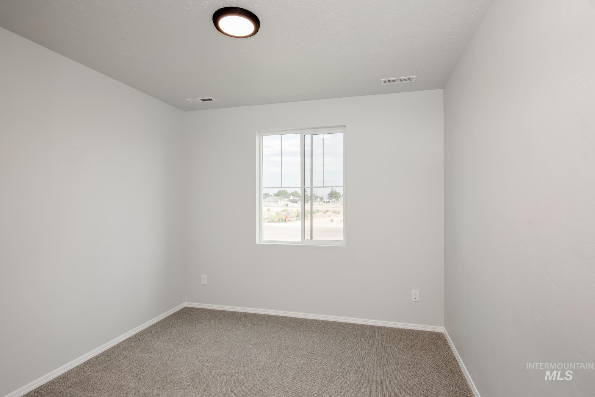 Empty room with carpet and baseboards