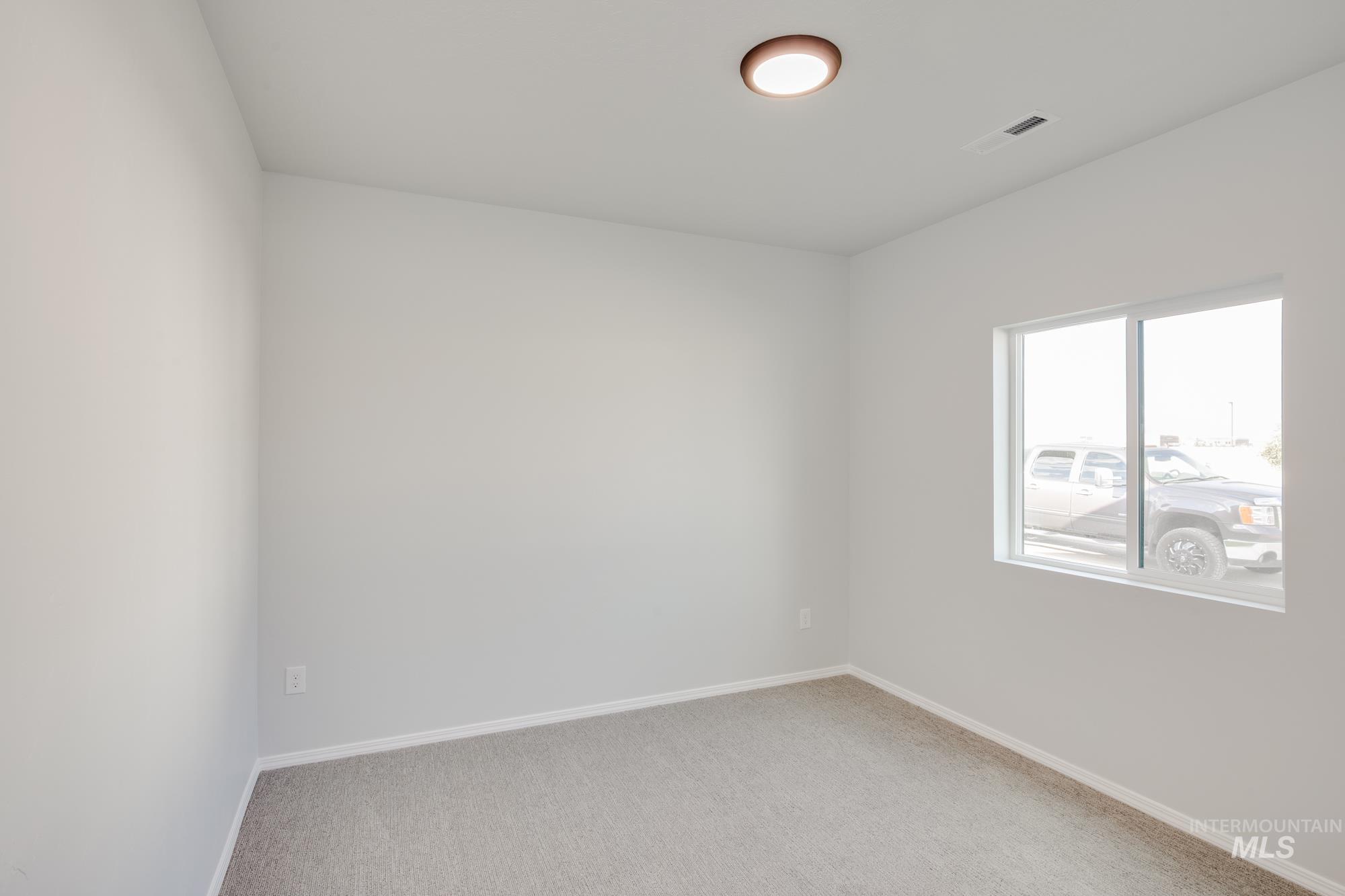 Empty room with carpet and baseboards