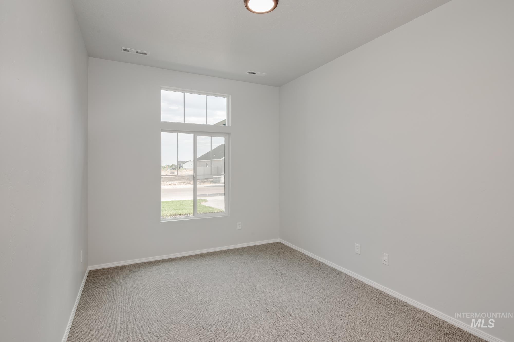Empty room featuring light carpet and baseboards