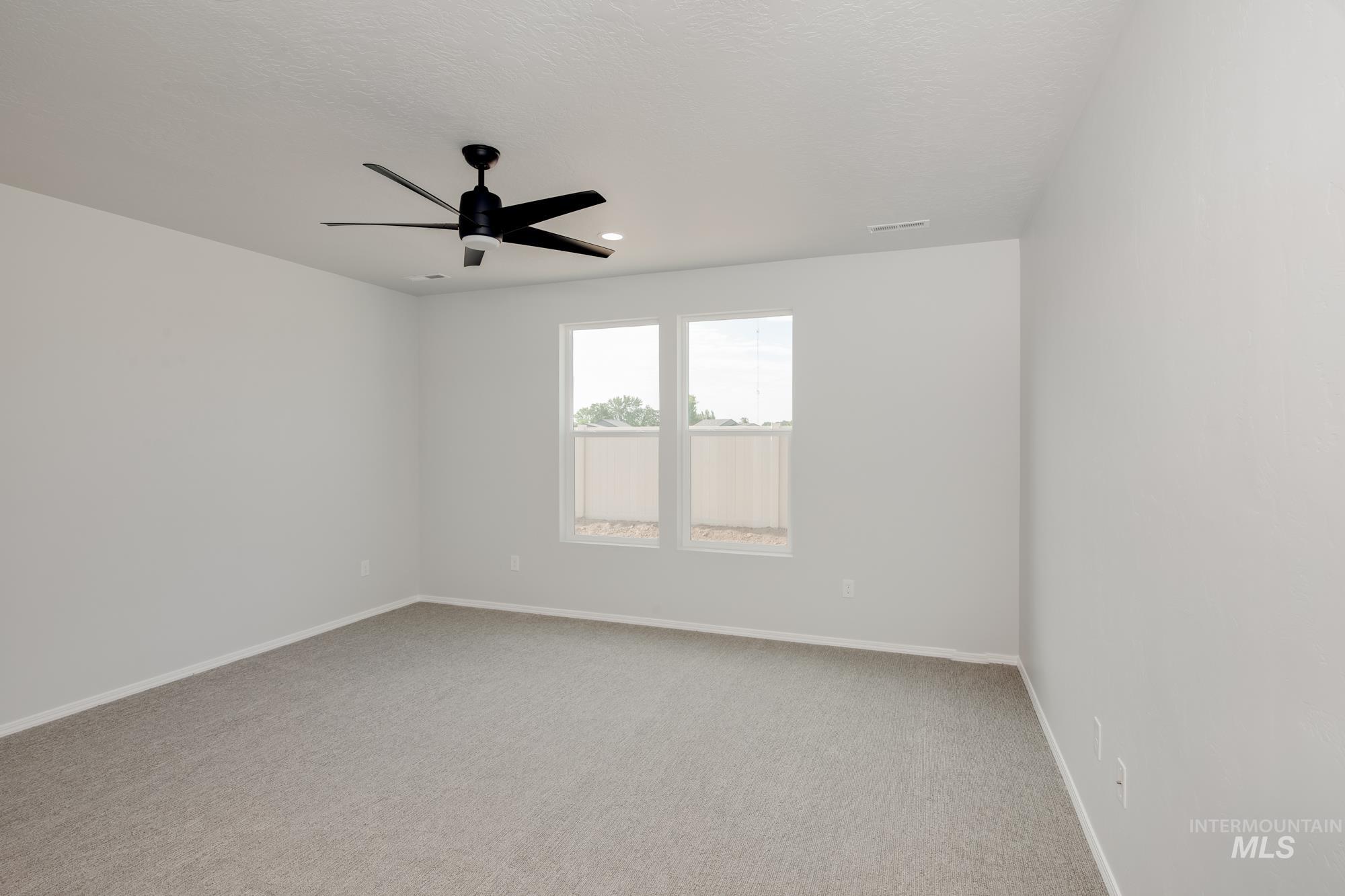 Empty room featuring light colored carpet, ceiling fan, and recessed lighting