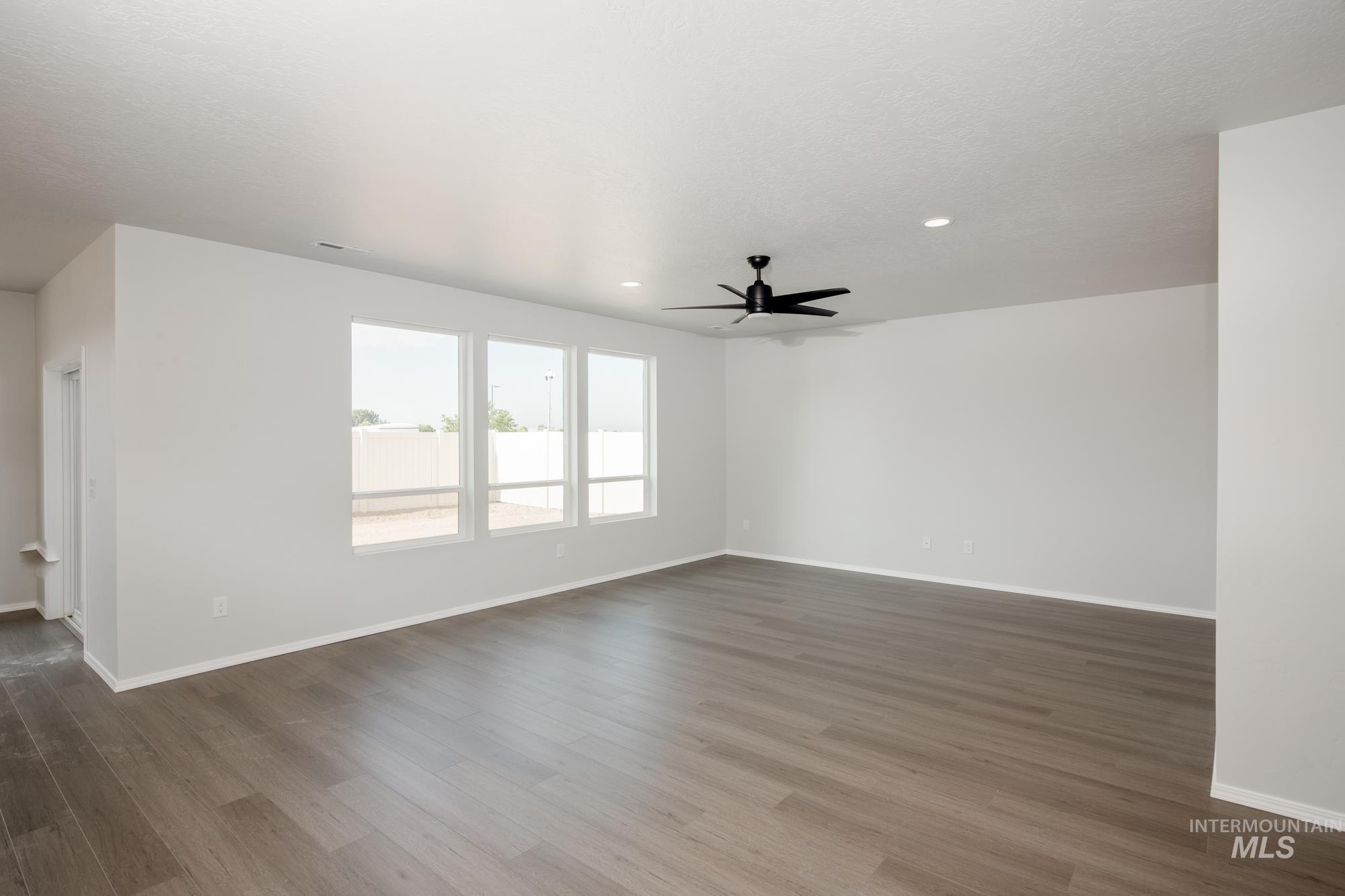 Spare room with dark wood finished floors, ceiling fan, and recessed lighting