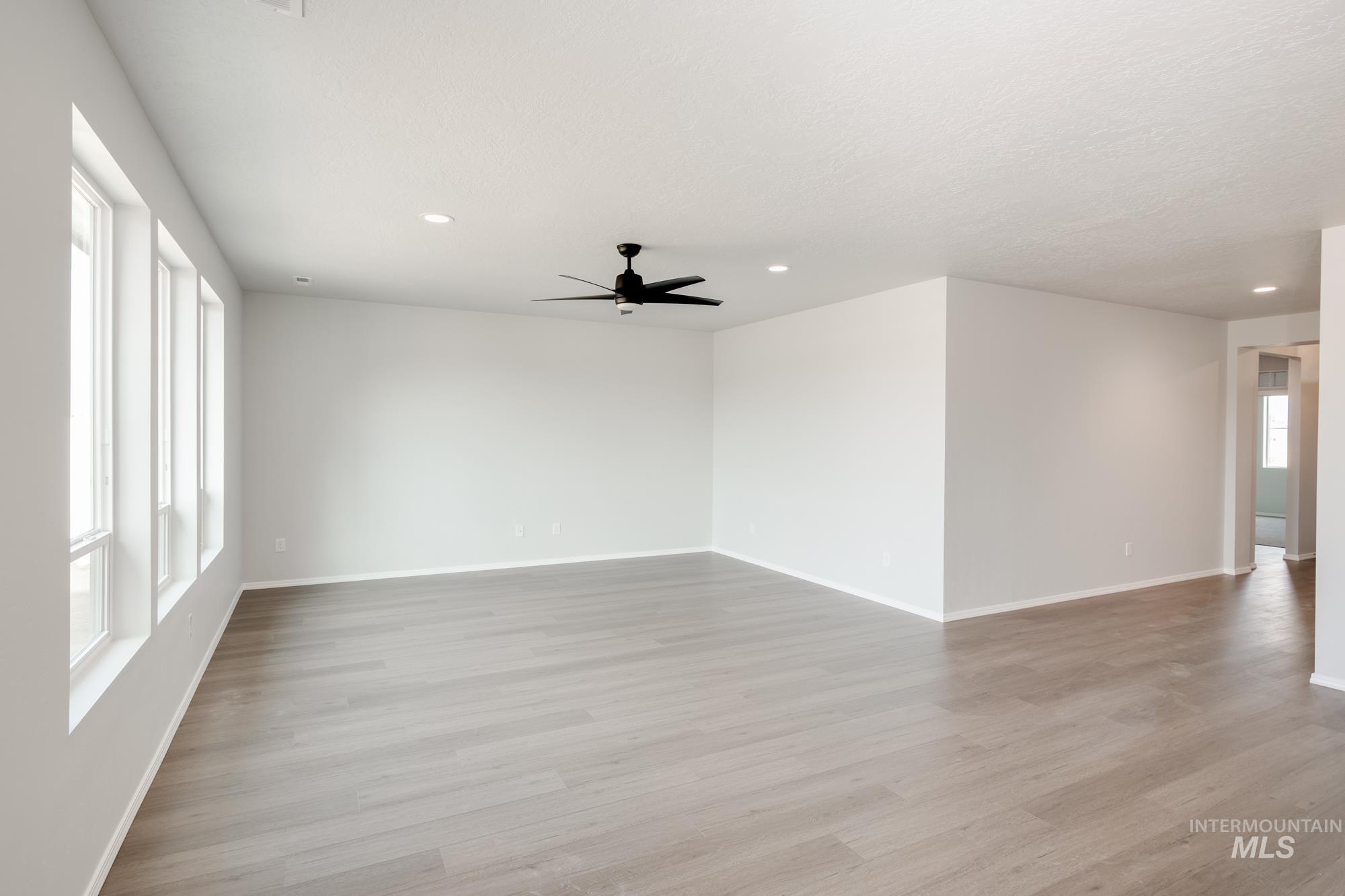 Unfurnished room featuring light wood finished floors, ceiling fan, and recessed lighting