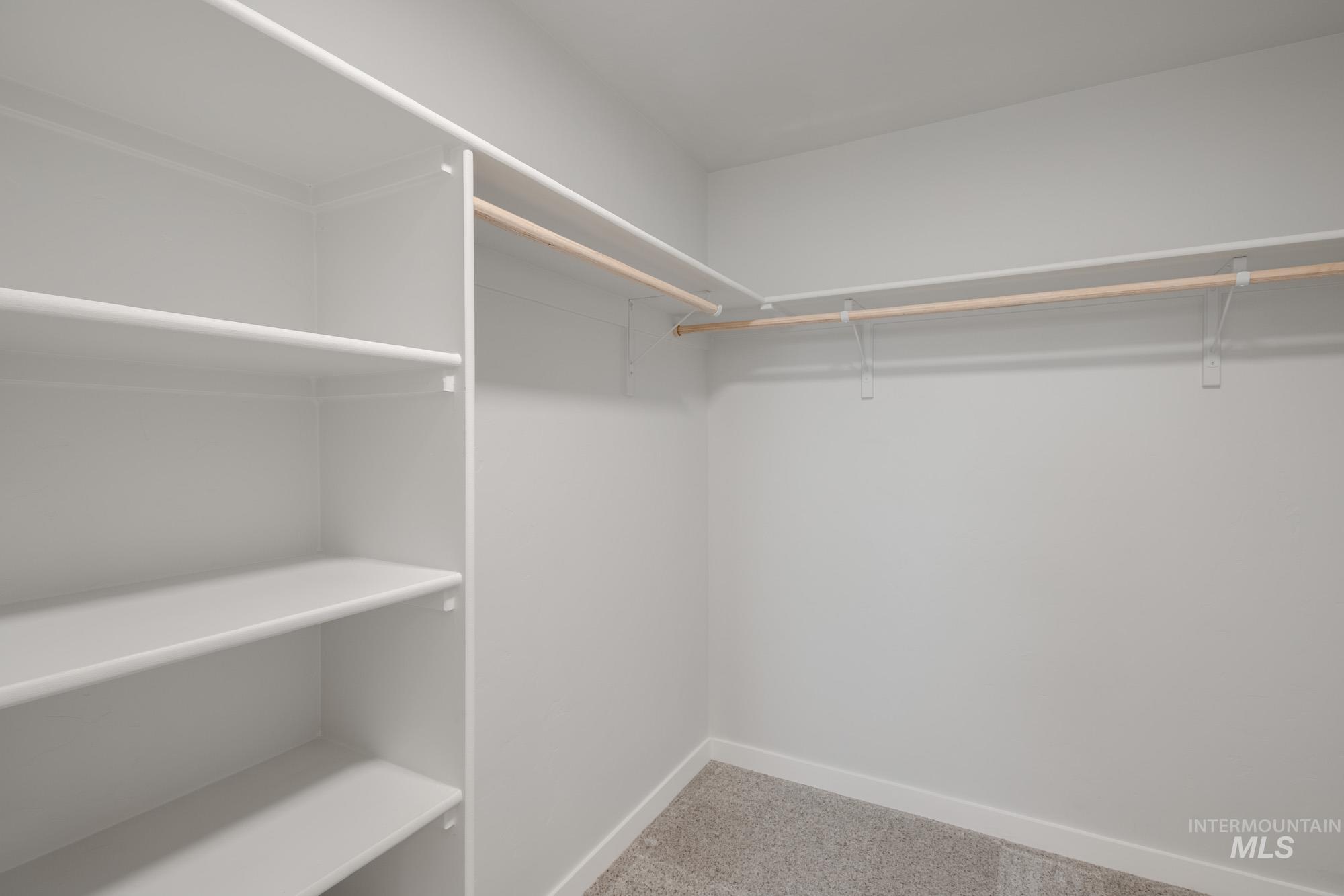 Spacious closet with light colored carpet